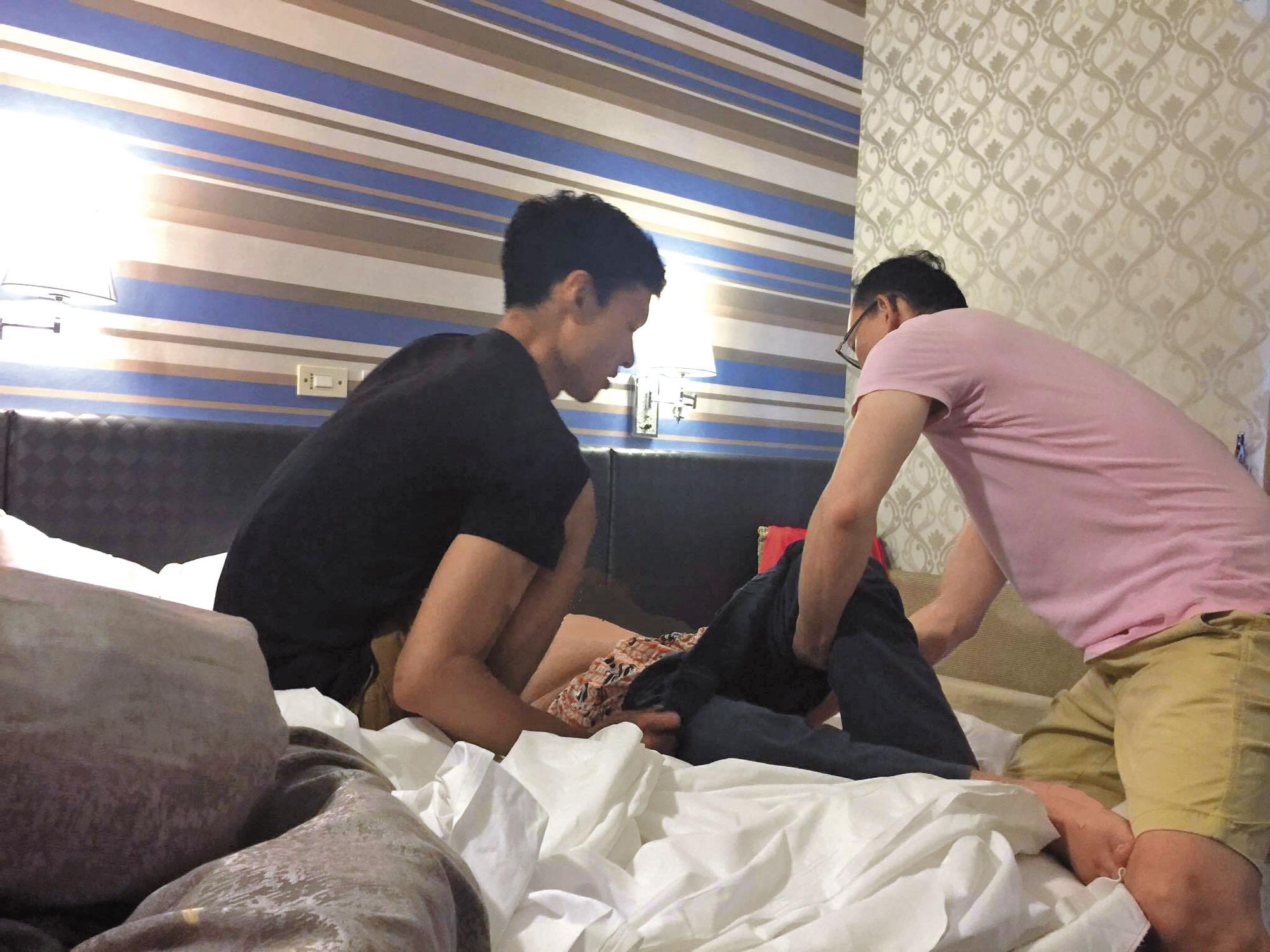 1個月前，周元大（左）初次提供性服務前，和「手天使」志工一起協助將行動不便的服務對象移動到床上。（手天使提供）