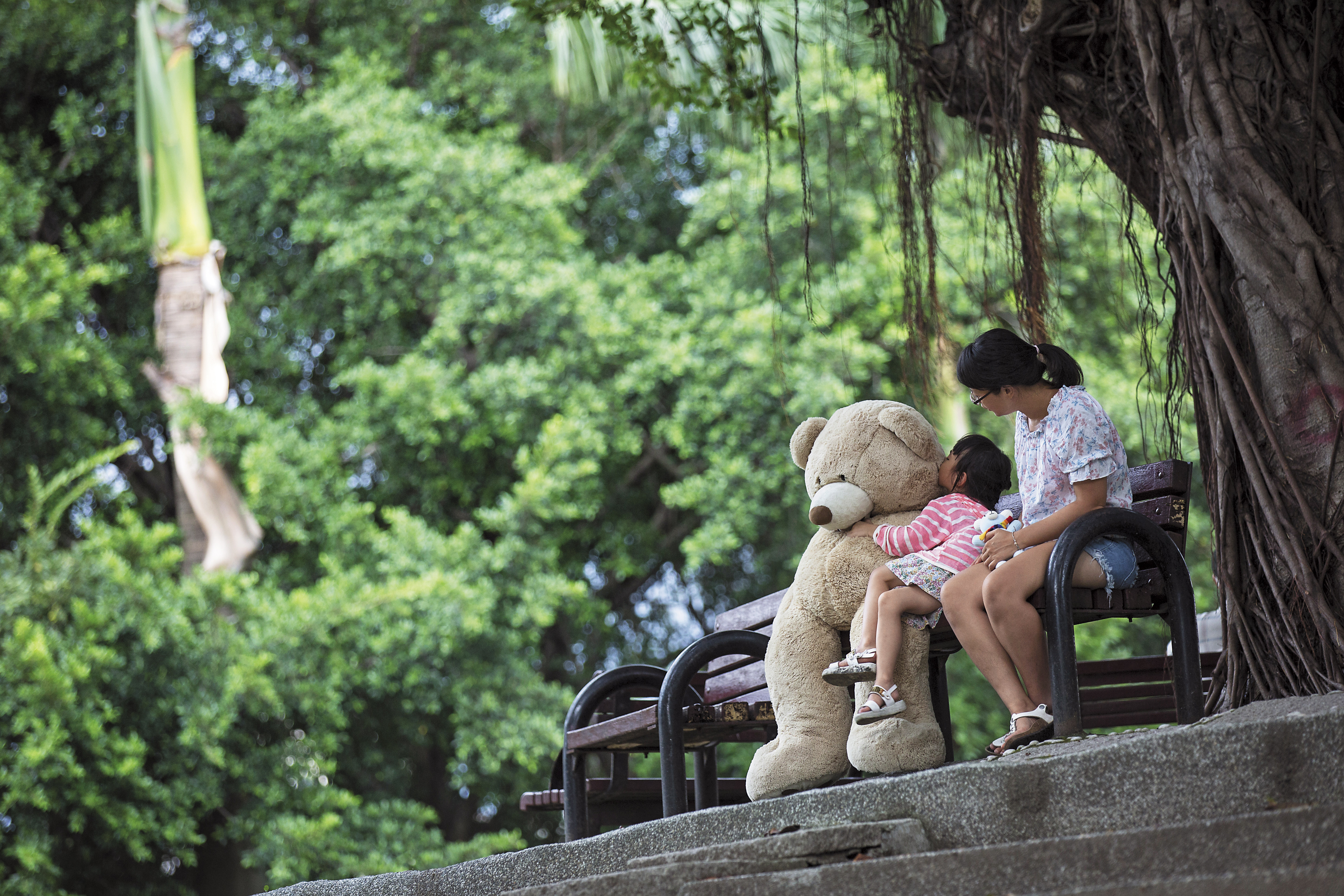 小怡（右）全職照顧女兒，拍照那天，看著女兒用力擁抱大熊娃娃，她一臉幸福滿足。