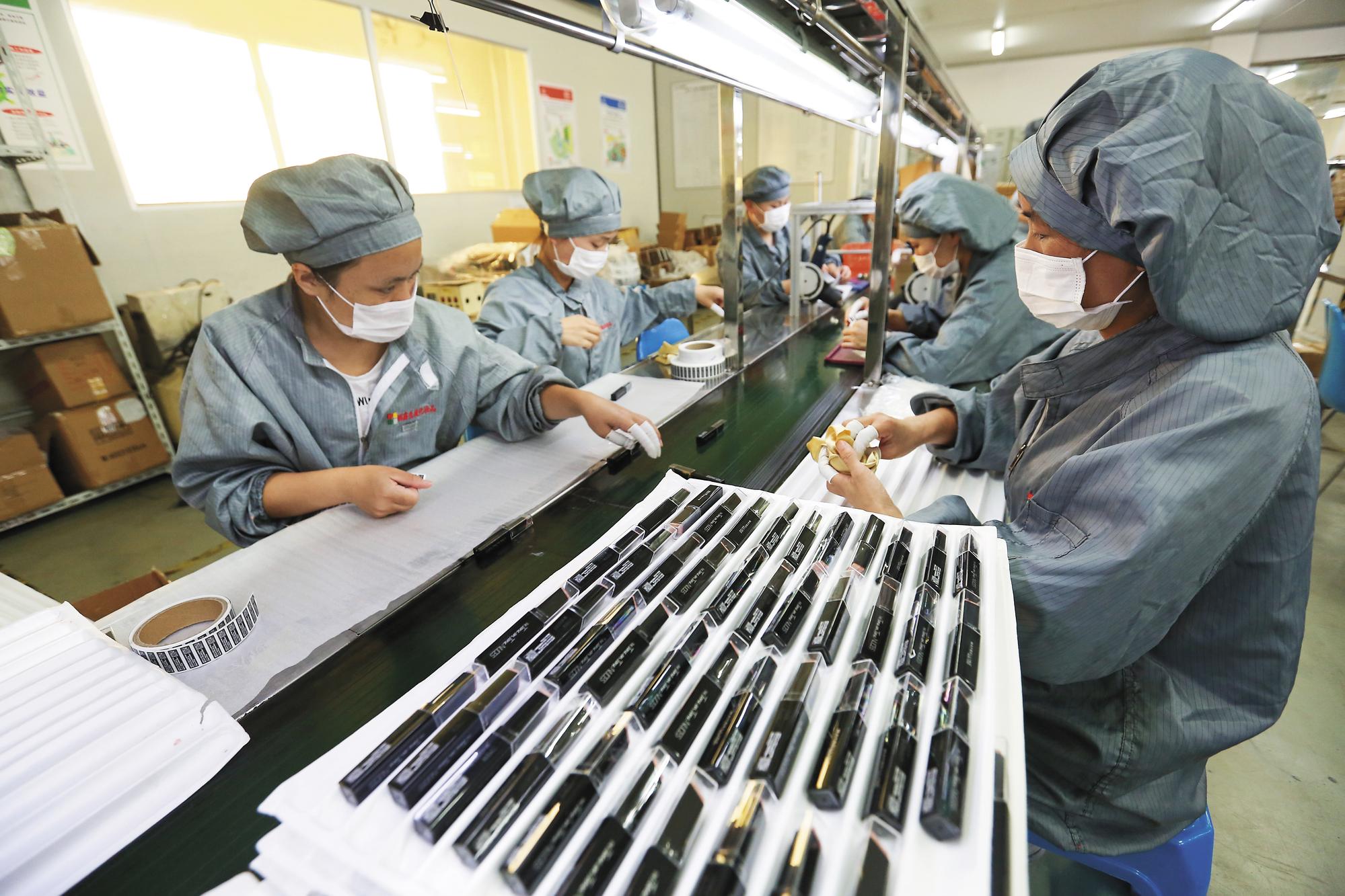 產線女工以手工貼標，並逐一確認產品狀況。