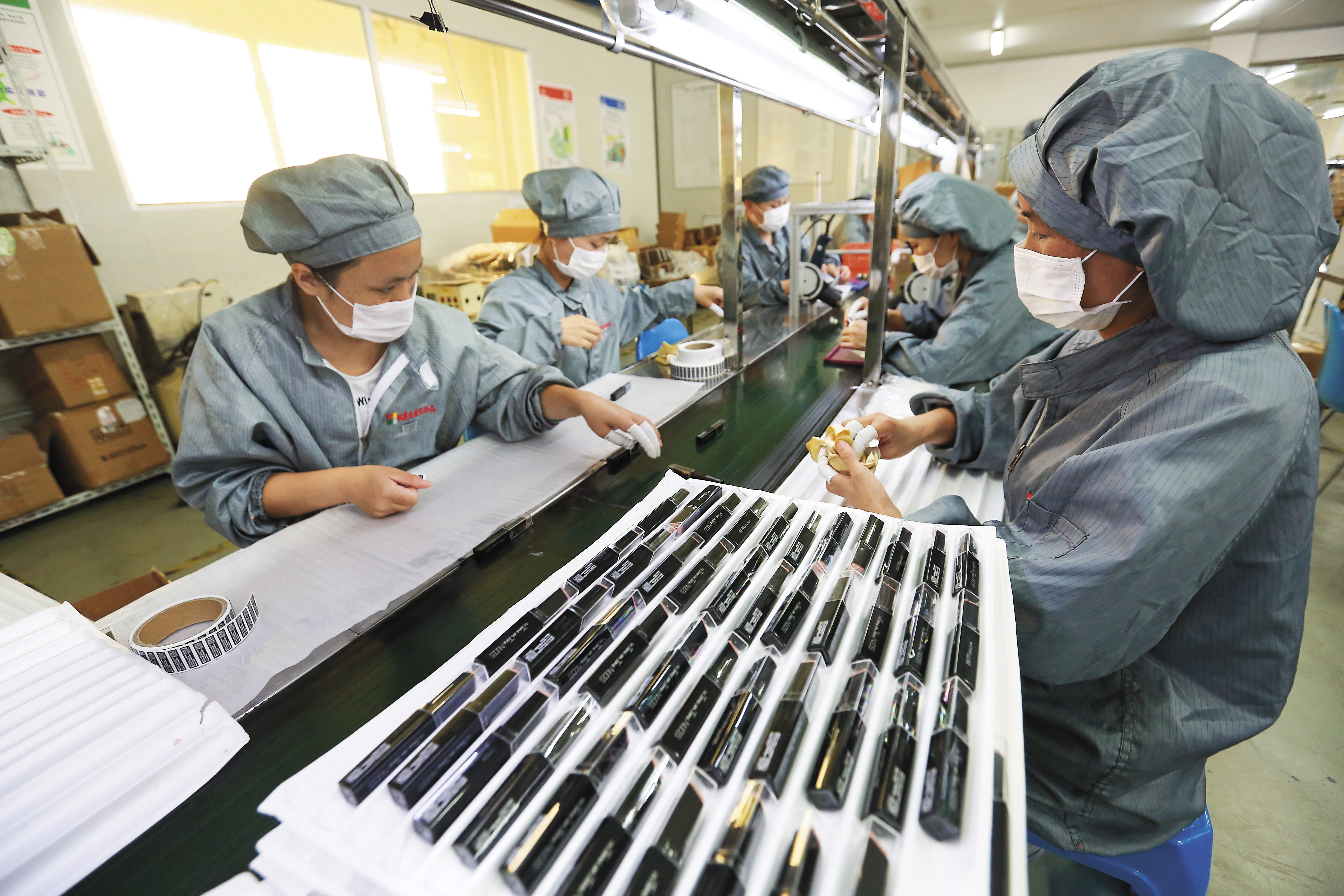 產線女工以手工貼標，並逐一確認產品狀況。