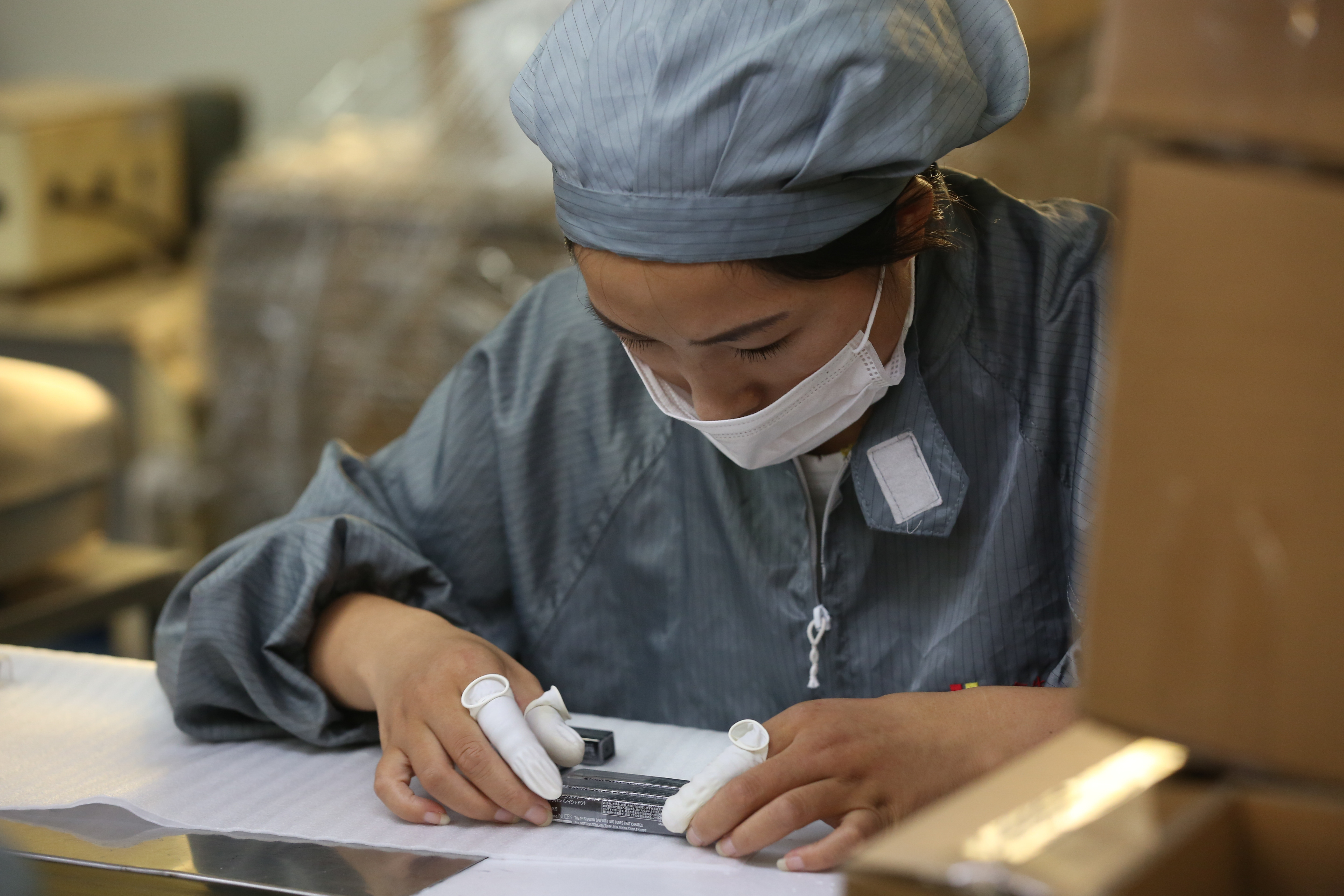 生產線女工以手工貼標，並逐一確認產品狀況。