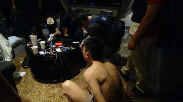 警方攻堅揪出躲在被窩裡的黃姓毒販（裸身者），坐他對面的送行者女友嚇得大哭。