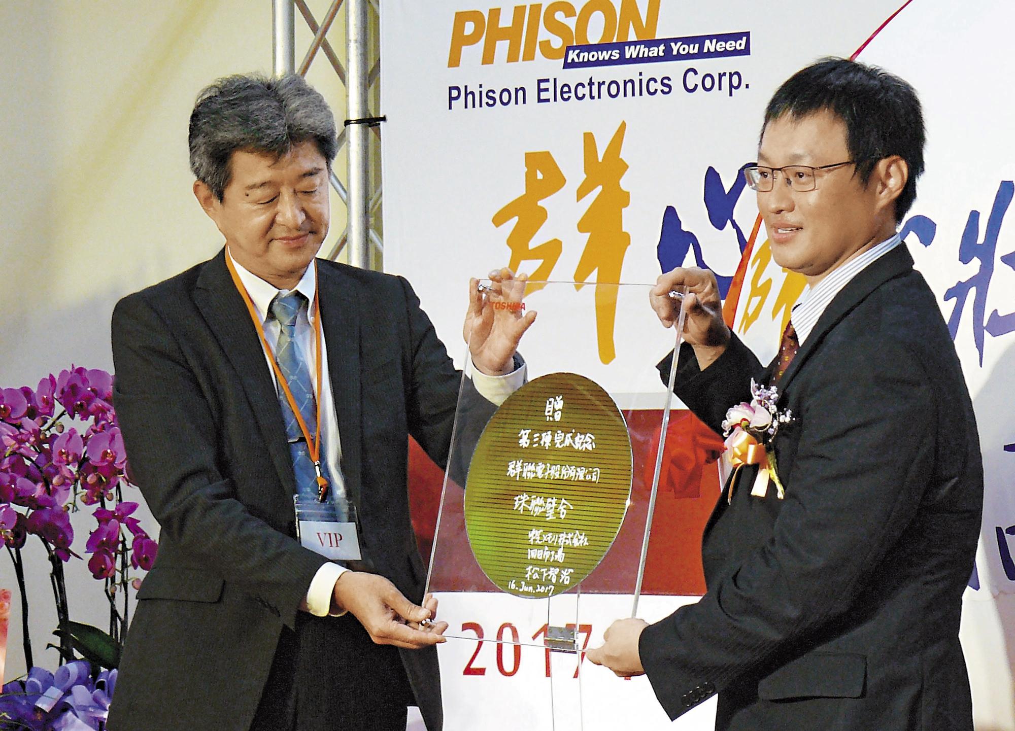 群聯竹南新廠落成時，日本東芝高層（左）專程來台祝賀，並致贈晶圓，由潘健成（右）收下。（中央社）
