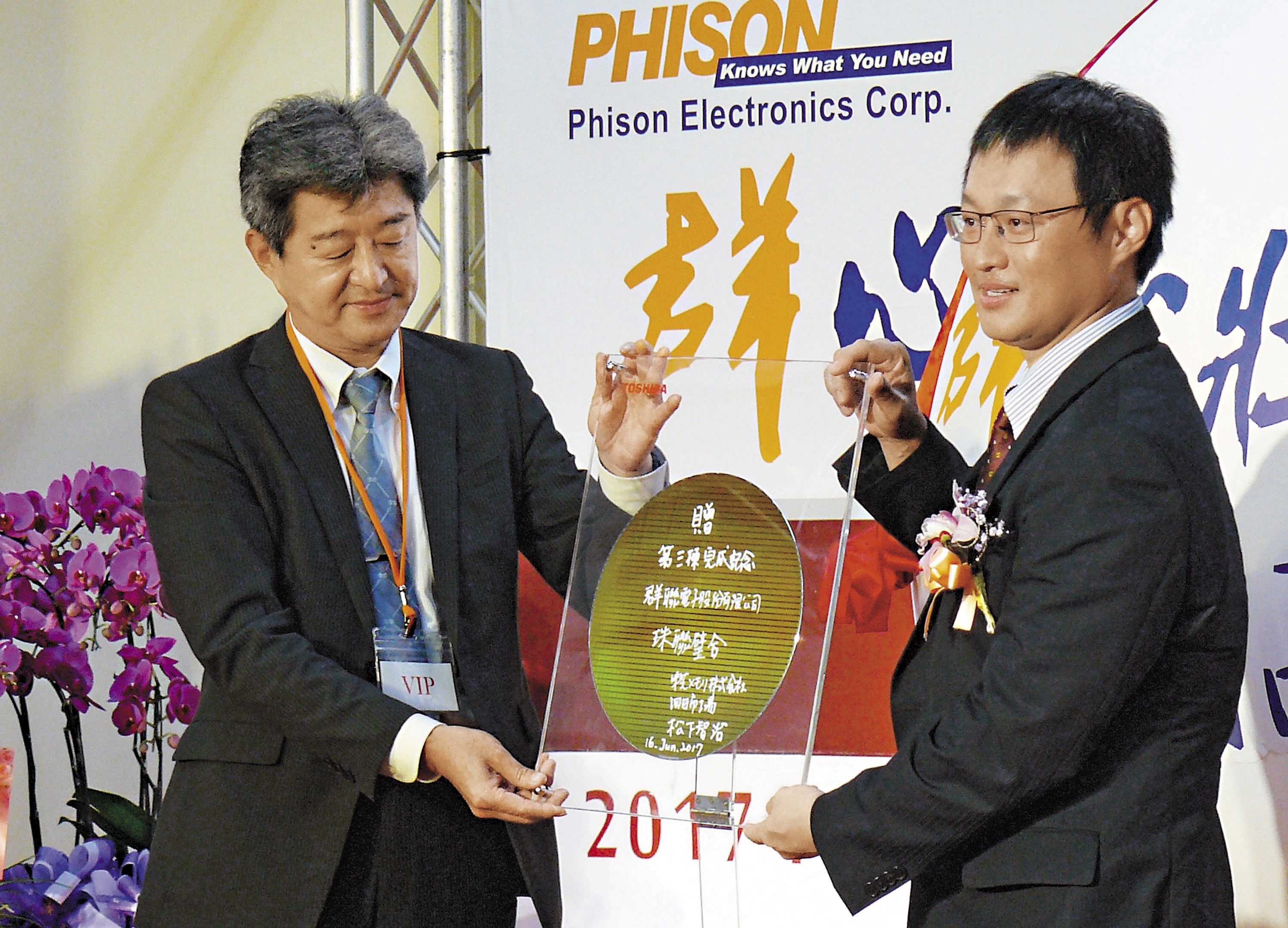群聯竹南新廠落成時，日本東芝高層（左）專程來台祝賀，並致贈晶圓，由潘健成（右）收下。（中央社）