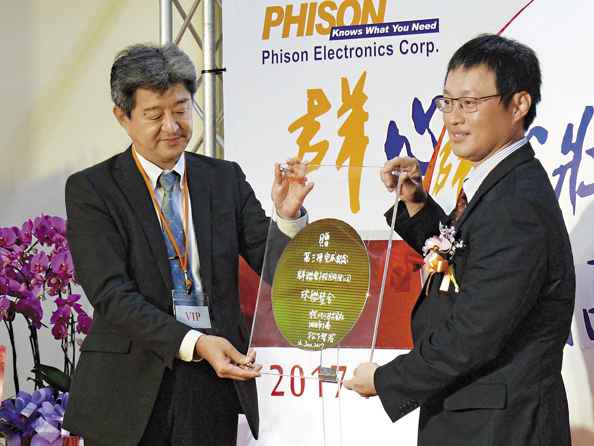 群聯竹南新廠落成時，日本東芝高層（左）專程來台祝賀，並致贈晶圓，由潘健成（右）收下。（中央社）