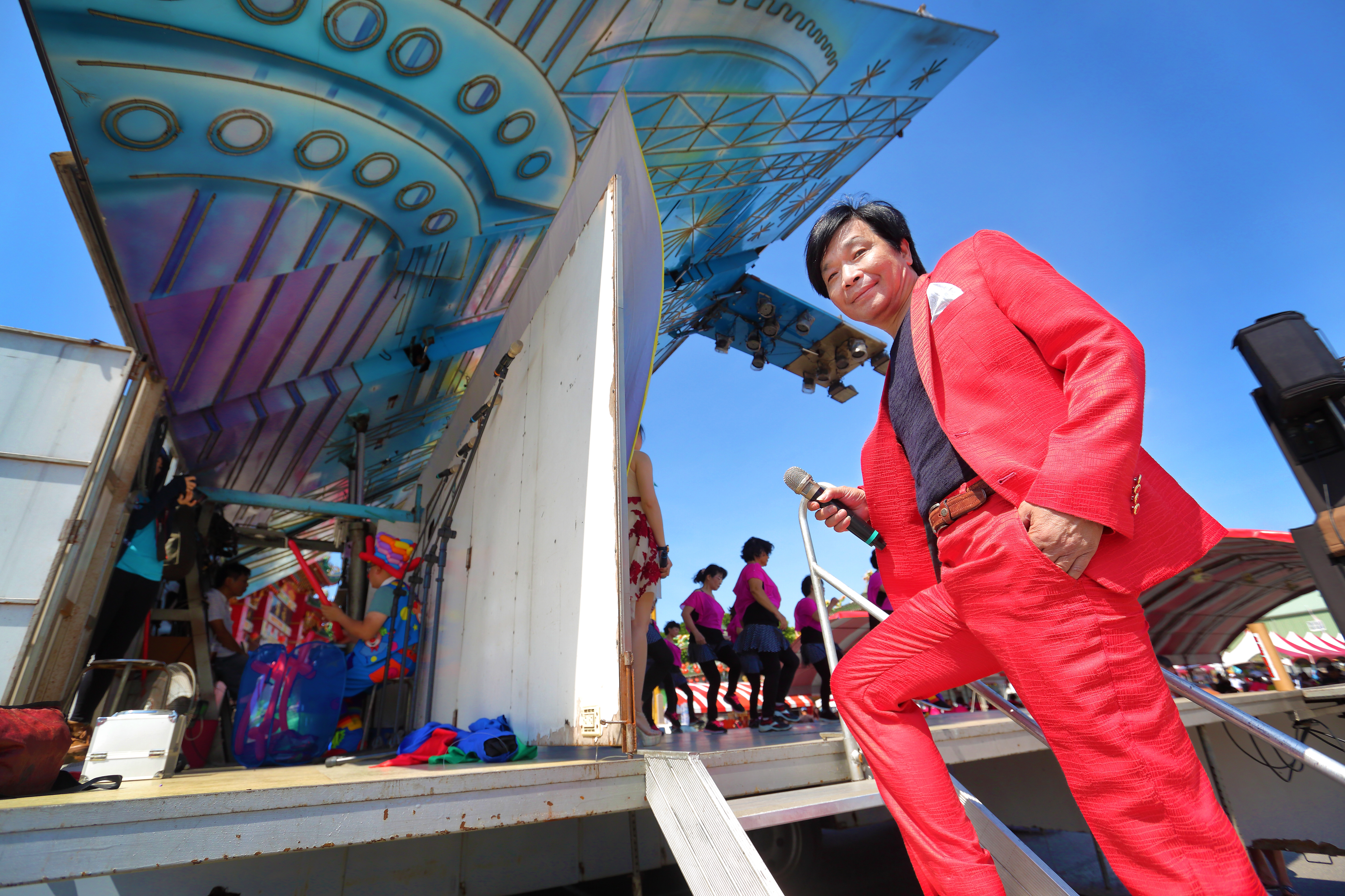 素人歌手洪便當受邀回故鄉，在王功漁火節活動中演出。一身紅的他，在藍天底下相當亮眼。