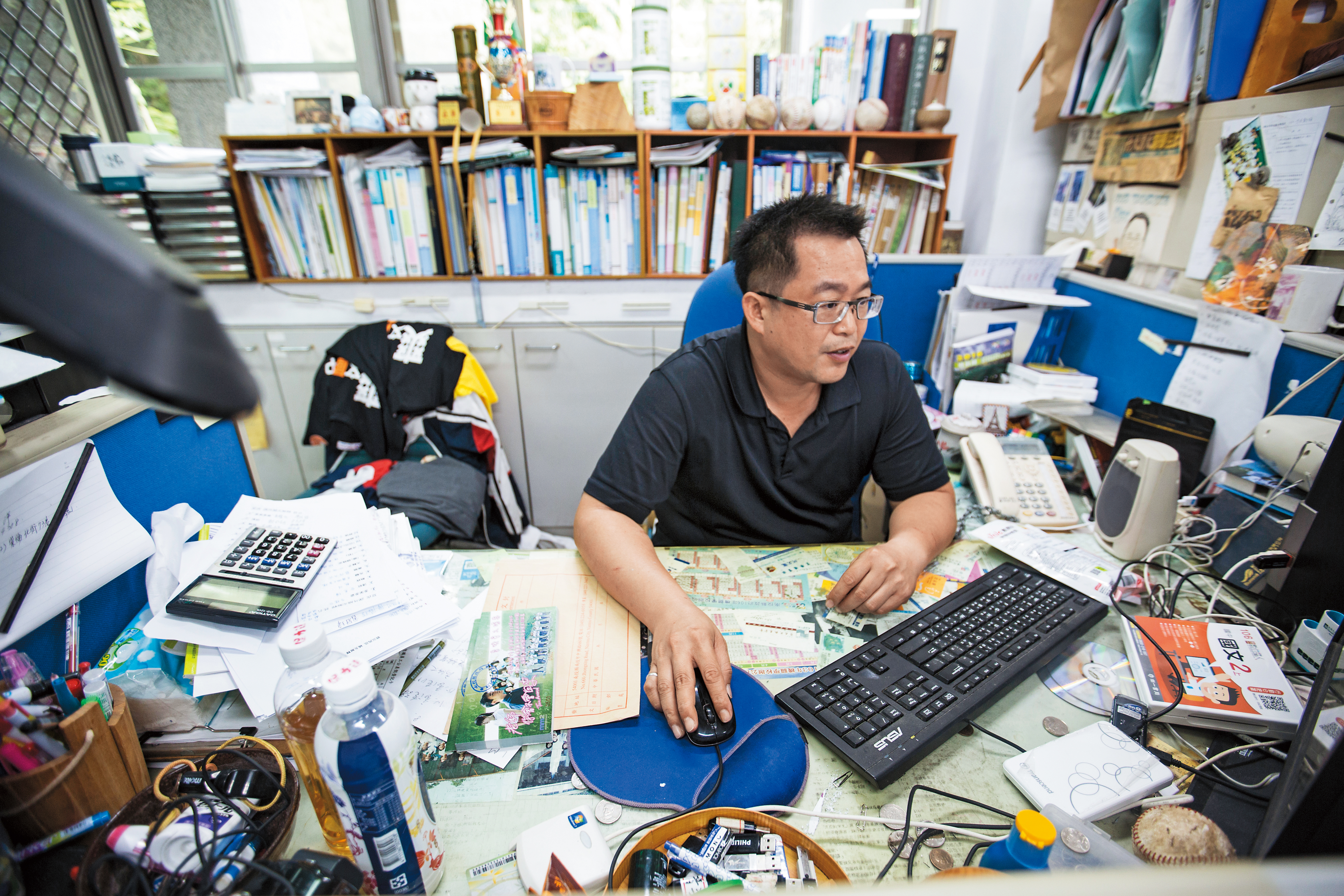 為什麼是教導主任？因為學生人數不足，教務與訓導處合併，王政忠行政兼教職，辦公桌上顯現的不是雜亂，而是繁忙。