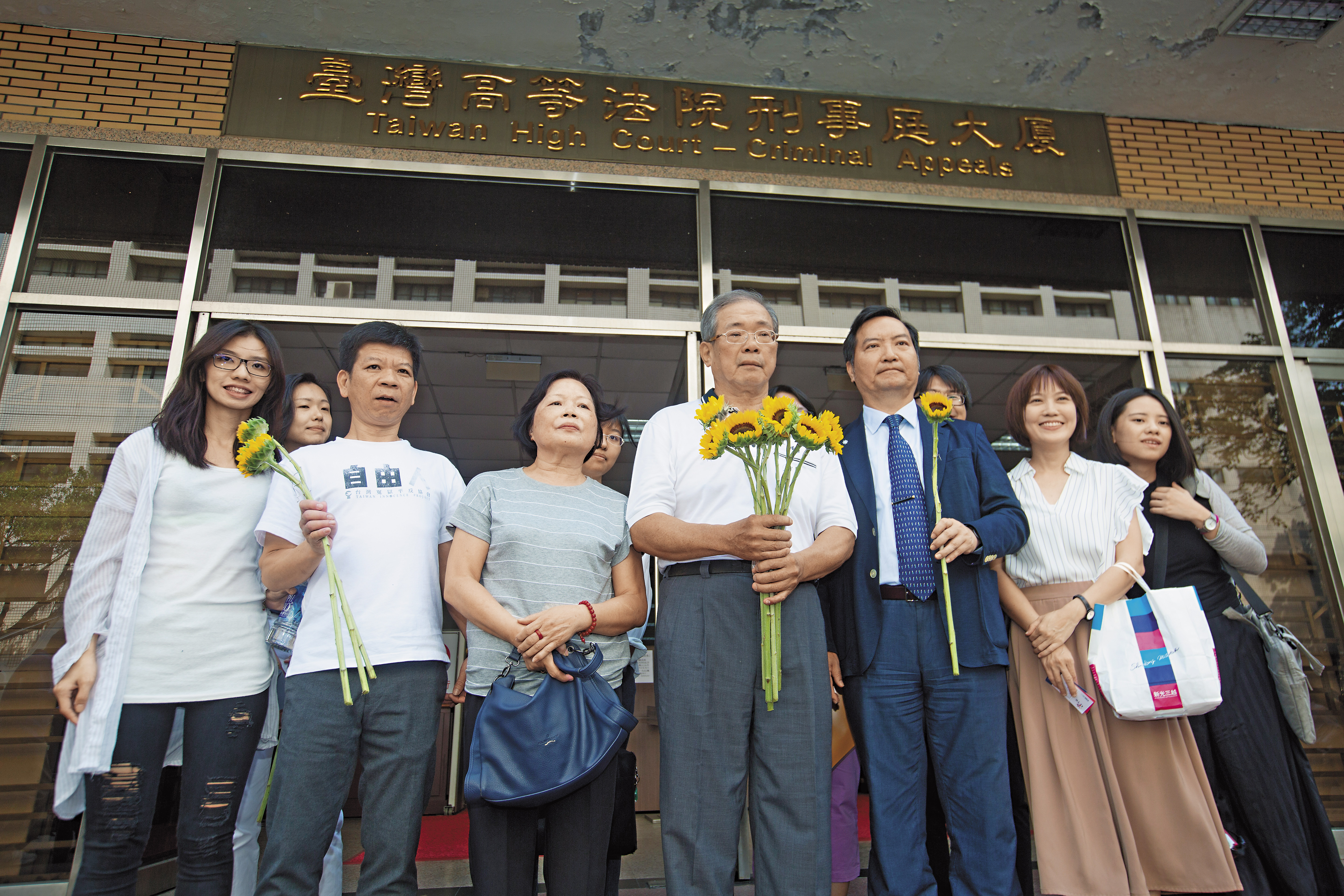 高院裁定准予再審後，蘇炳坤（前左4）在太太（前左3）、律師等人陪同下接受媒體採訪。前左2為仍在爭取冤案平反的鄭性澤。
