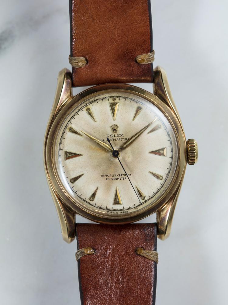 《ROLEX Ref.6018「Bubble Back」》功能：時、分、秒指示/機芯：自動上鍊機芯/年份：1949年。俗稱「泡泡背」的Ref.6018是老勞玩家必收的逸品，而這只泡泡背最有趣之處，除了錶耳是俗稱Bombay Lug孟買腳的特殊設計外，裝配的Cal.630機芯也是鍍金的特殊版本，跟一般鍍銠的銀白色機芯大異其趣，寶石數也較一般版的17石多，高達25石，為ROLEX的特殊試做款式。