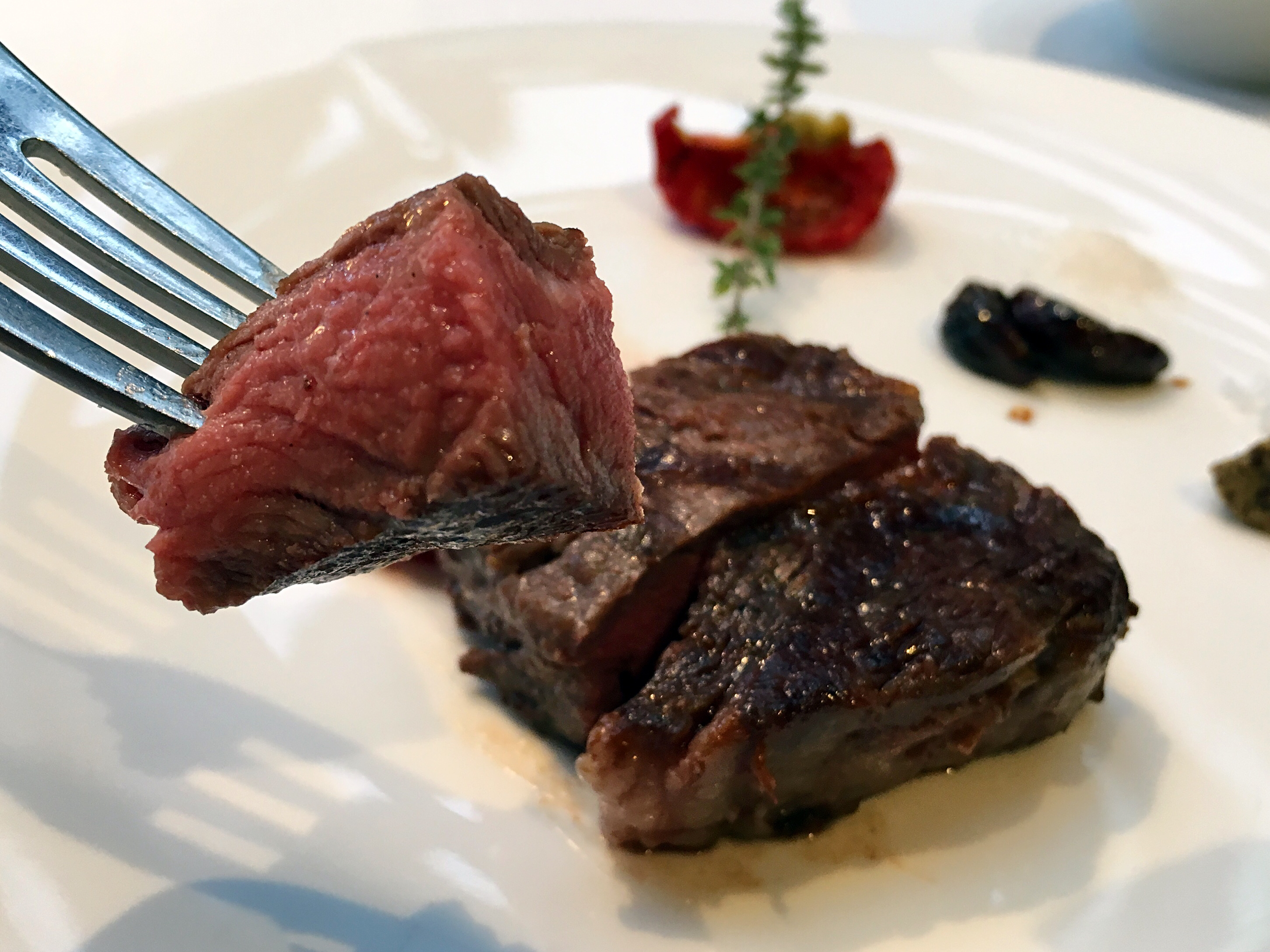 「美國Prime杉河農場溼式熟成45天肋眼牛排12oz」肉質柔嫩多汁、風味濃郁，搭配風乾番茄、紅酒漬蒜頭或松露鹽，能吃出牛肉不同風味。（1,780元／份）