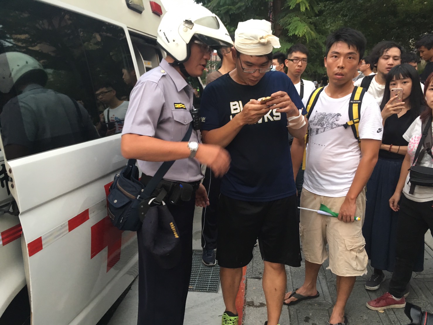 濺血學生與警方使用手機比對攻擊者。(翻攝畫面)