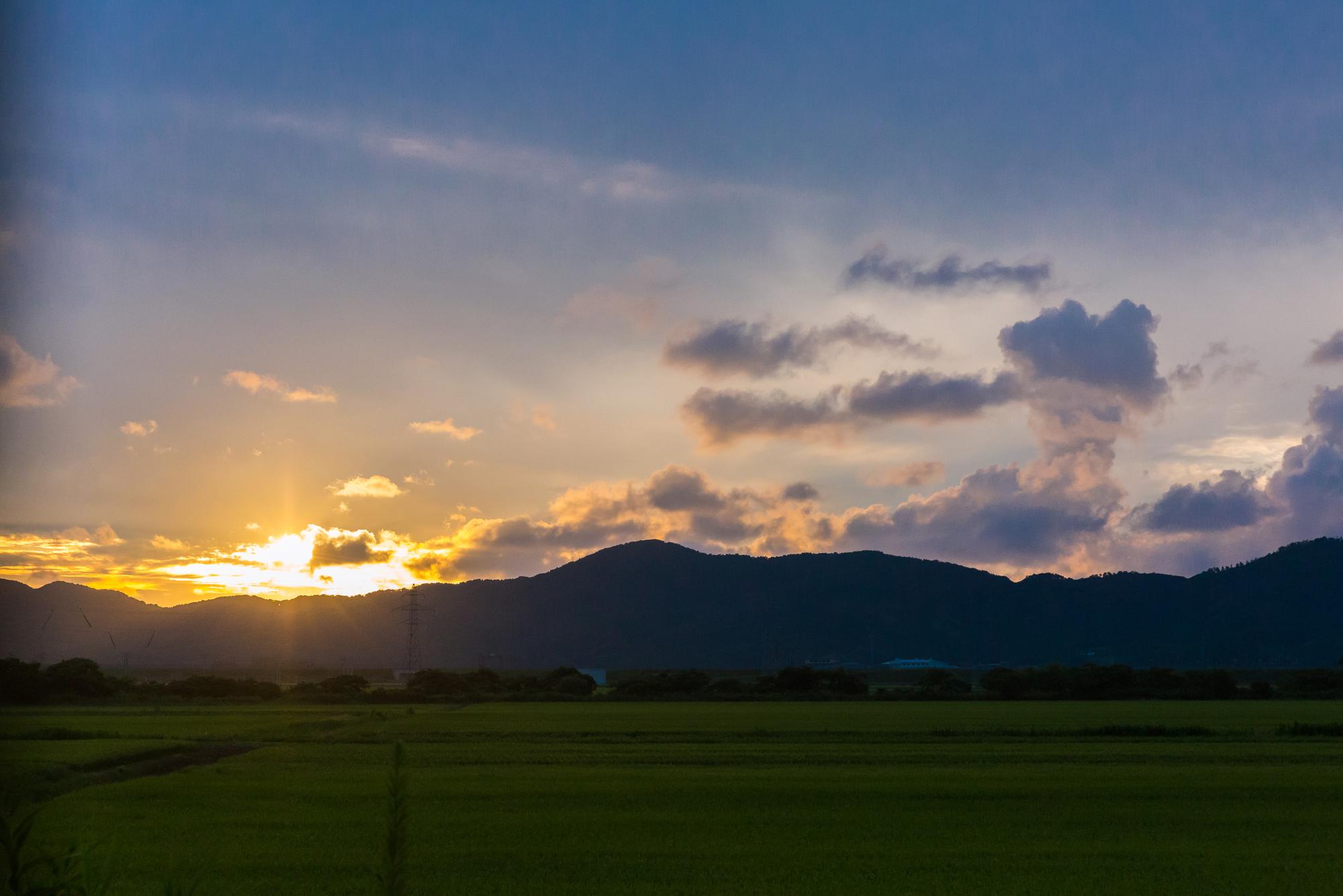 坐在遊覽車上打瞌睡碰到車窗驚醒，正是傍晚時分夕陽已經掉落在山的另一頭發出金黃色光芒。