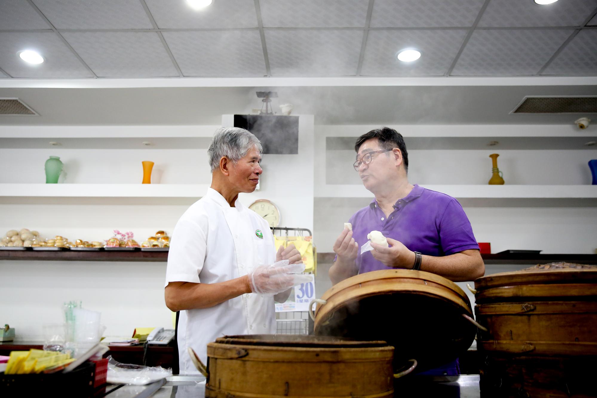 文藝大叔王浩一(右)帶我們走訪台南私房老餅店,他和「萬川號」老師傅蔡煌明(左)談起店裡百年老包子的身世。