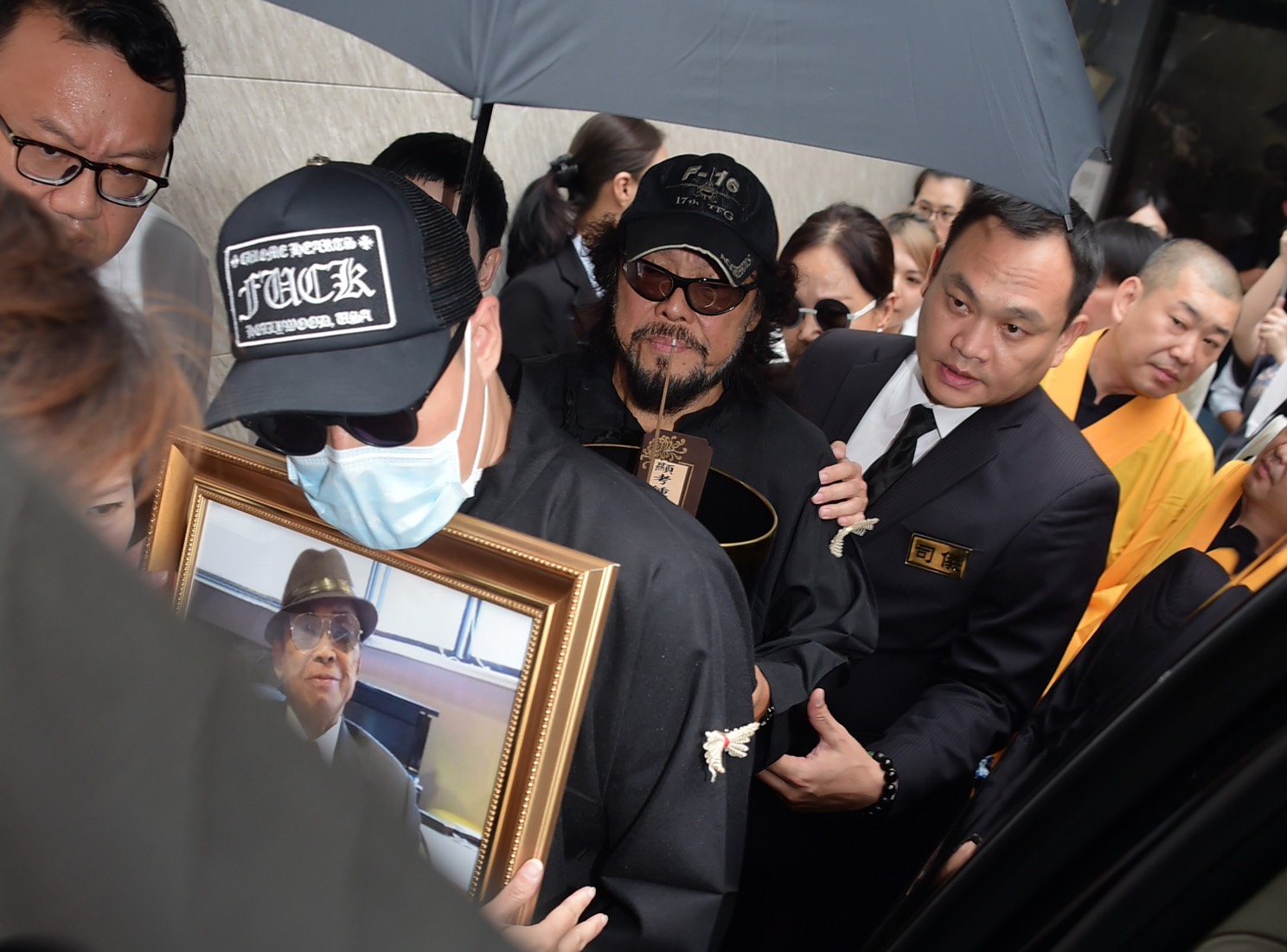 張少青抱著爺爺遺照，送他最後一程。