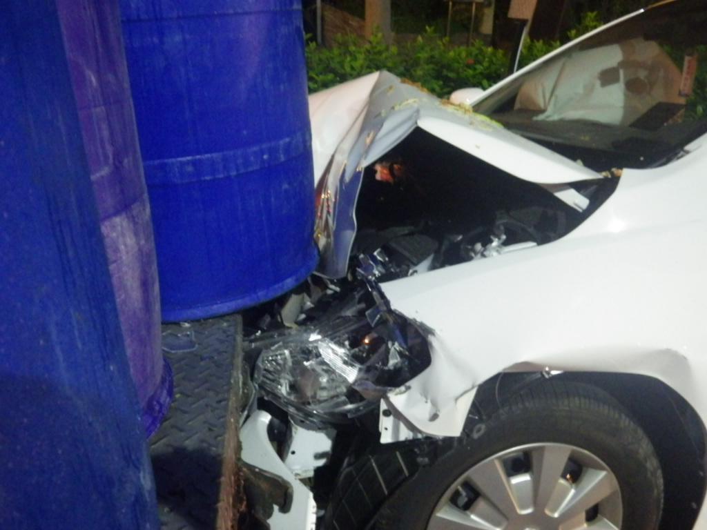 小轎車追撞餿水車，車頭凹陷可見當時力道之大，餿水車主正在搬運餿水桶，還好命大逃過一劫。