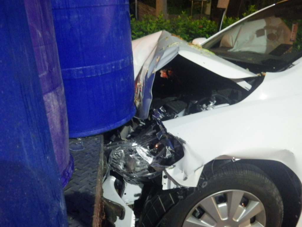 小轎車追撞餿水車，車頭凹陷可見當時力道之大，餿水車主正在搬運餿水桶，還好命大逃過一劫。