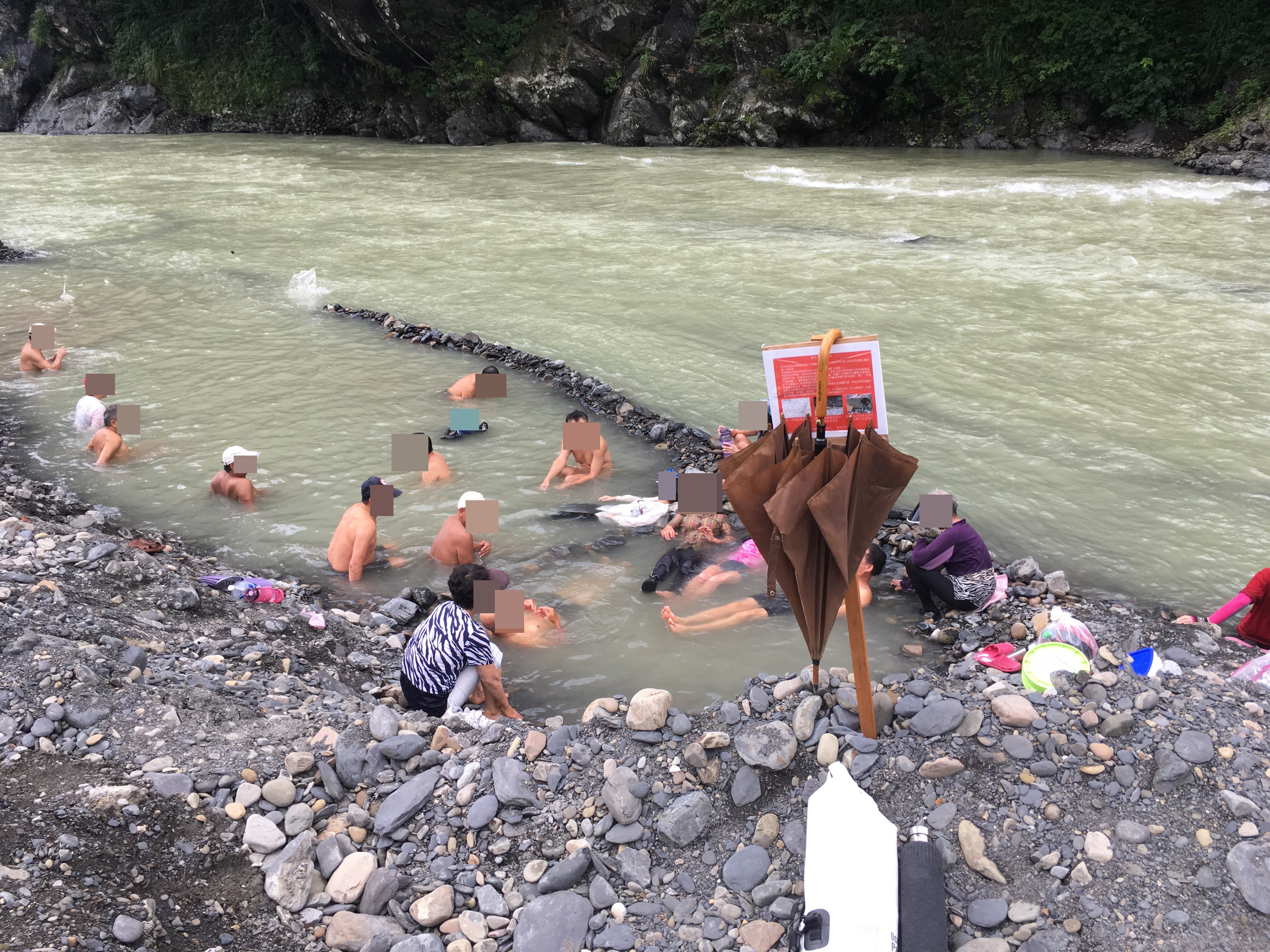 民眾無視禁令進入封閉區，溪邊矗立的告示牌甚至成為民眾的傘架。