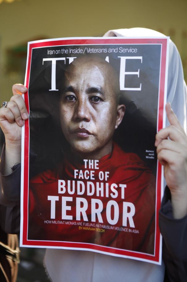 印尼人9月15日在緬甸大使館外聲援羅興亞人，一名抗議者高舉著時代雜誌前年以威拉杜為封面的海報，標題寫著：「緬甸恐怖主義的臉孔」。（東方IC）