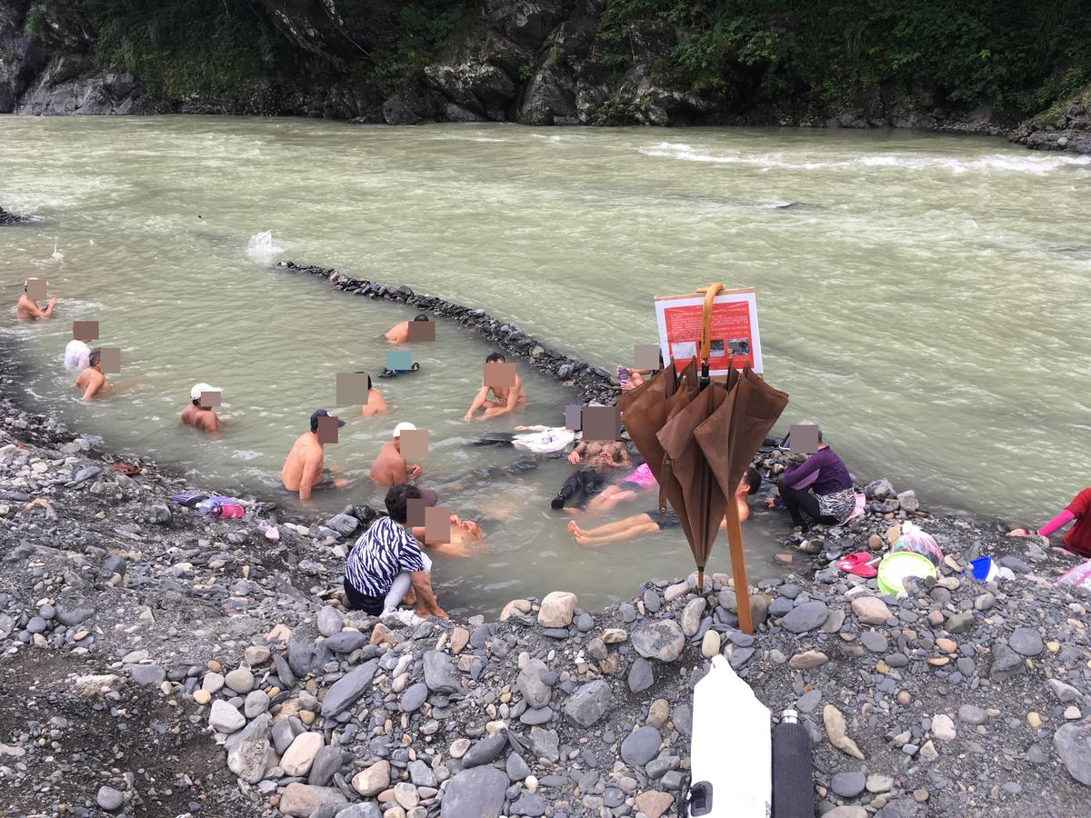民眾無視禁令進入封閉區，溪邊矗立的告示牌甚至成為民眾的傘架。