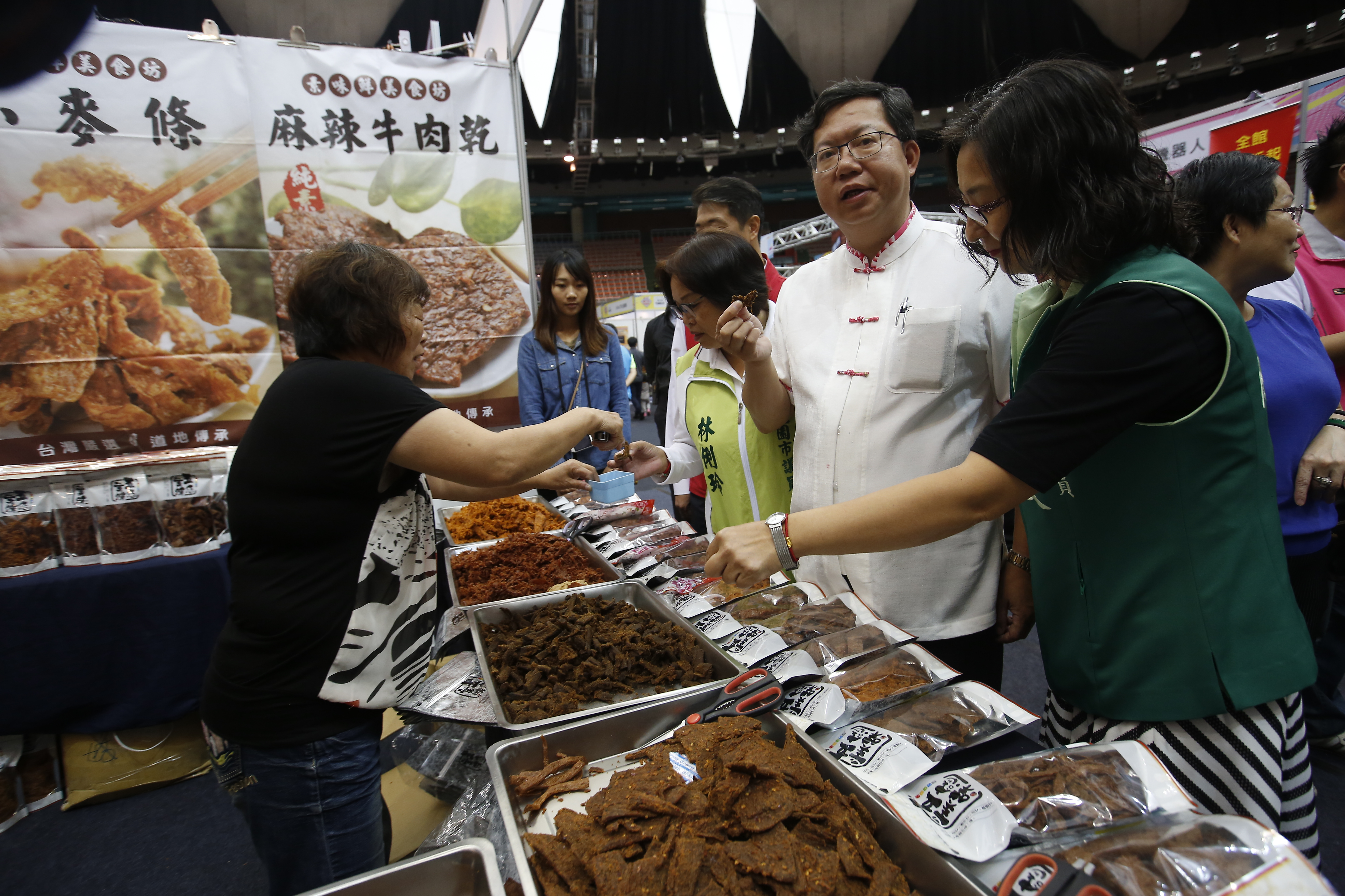 桃園市長鄭文燦參加購物展開幕典禮，各種美食讓他停不下手。