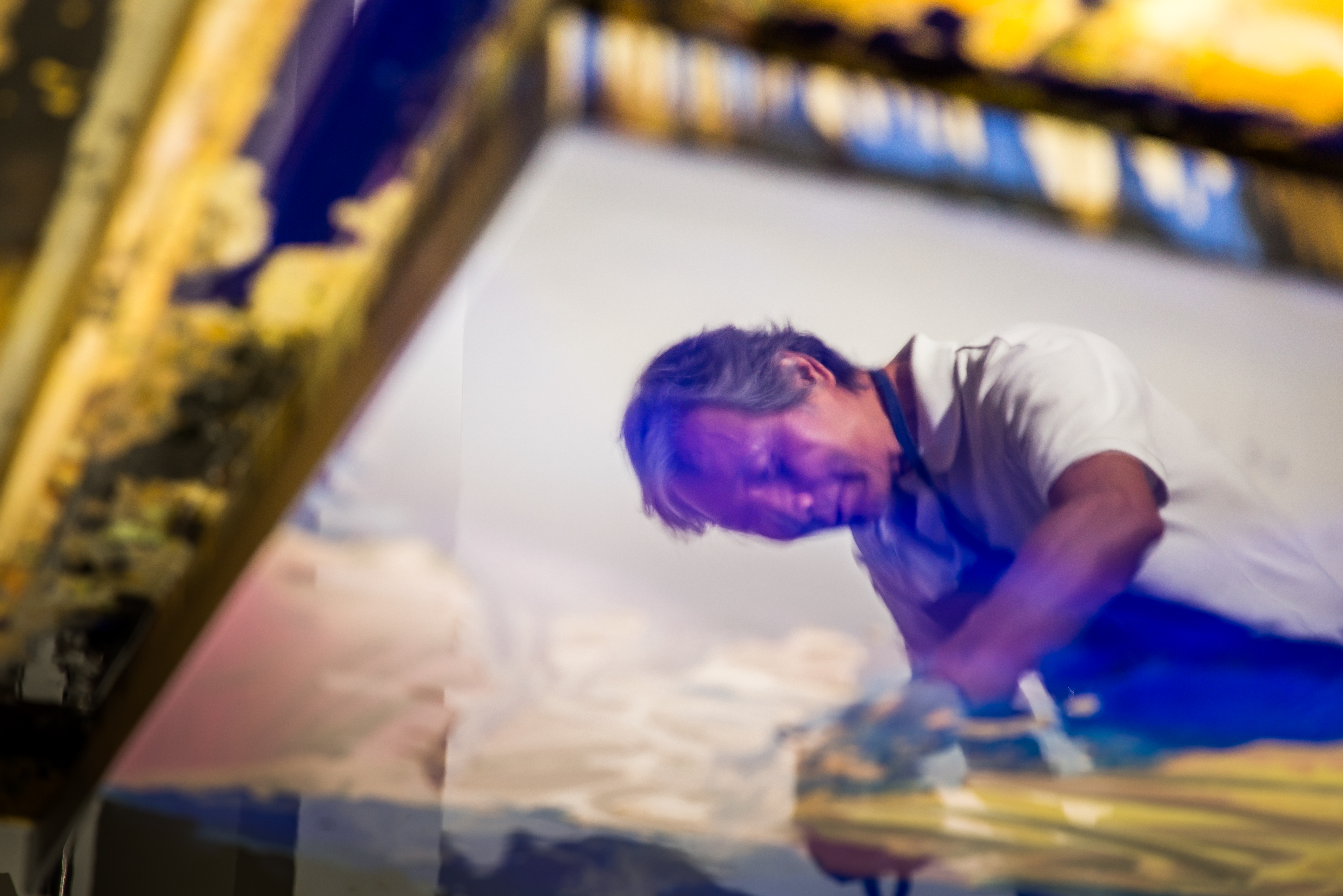 作畫中的蔡文雄，畫板上的油彩出現他的倒影。