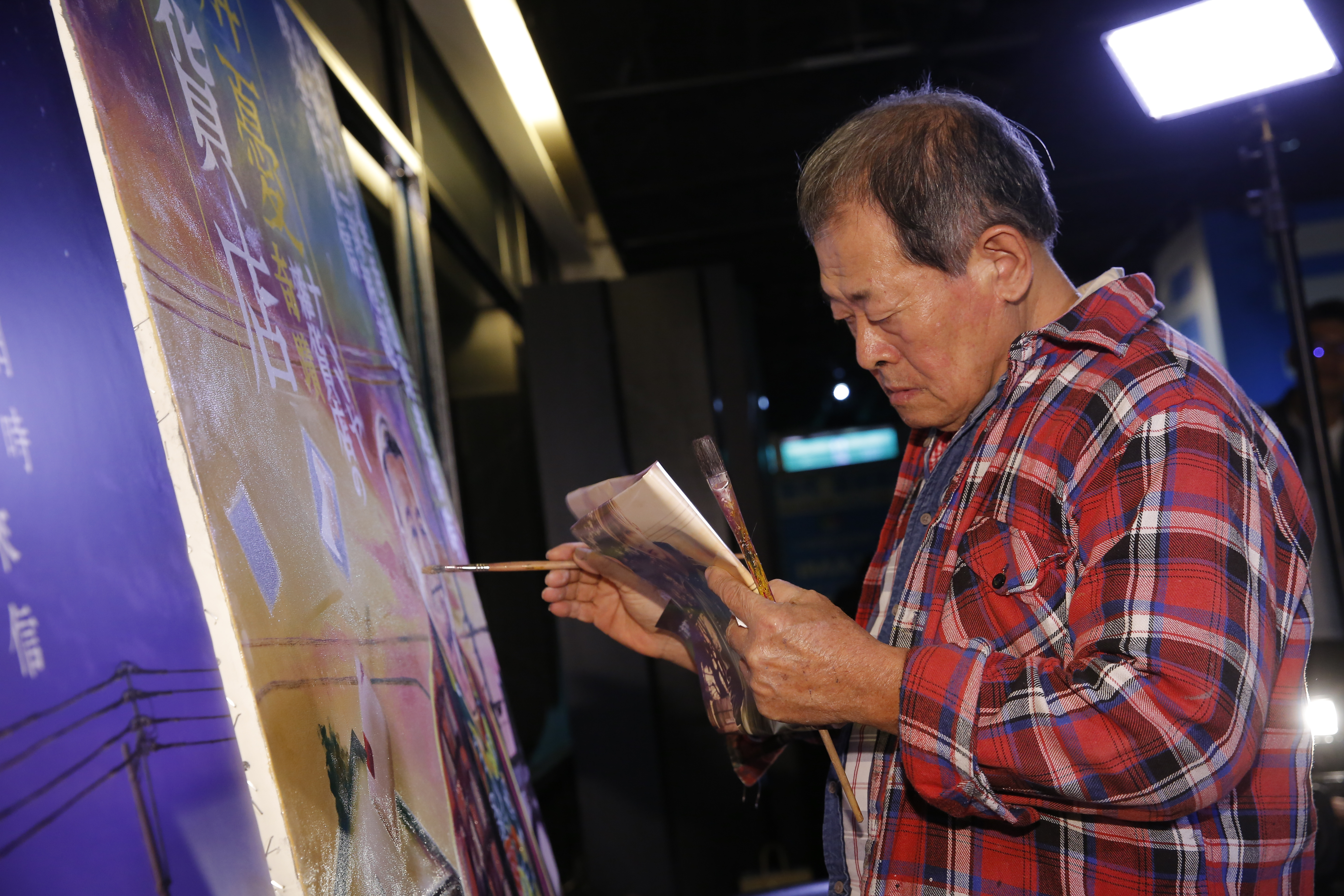 電影看板畫師顏振發師傅一筆一劃用畫筆繪出《解憂雜貨店》海報上的小信封。