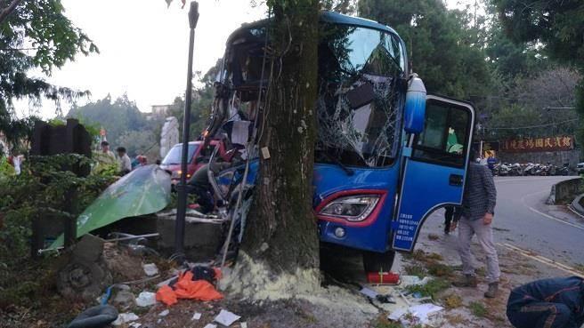 遊覽車在下坡路段先撞上意象招牌,在衝撞路樹才停止。(消防局提供)