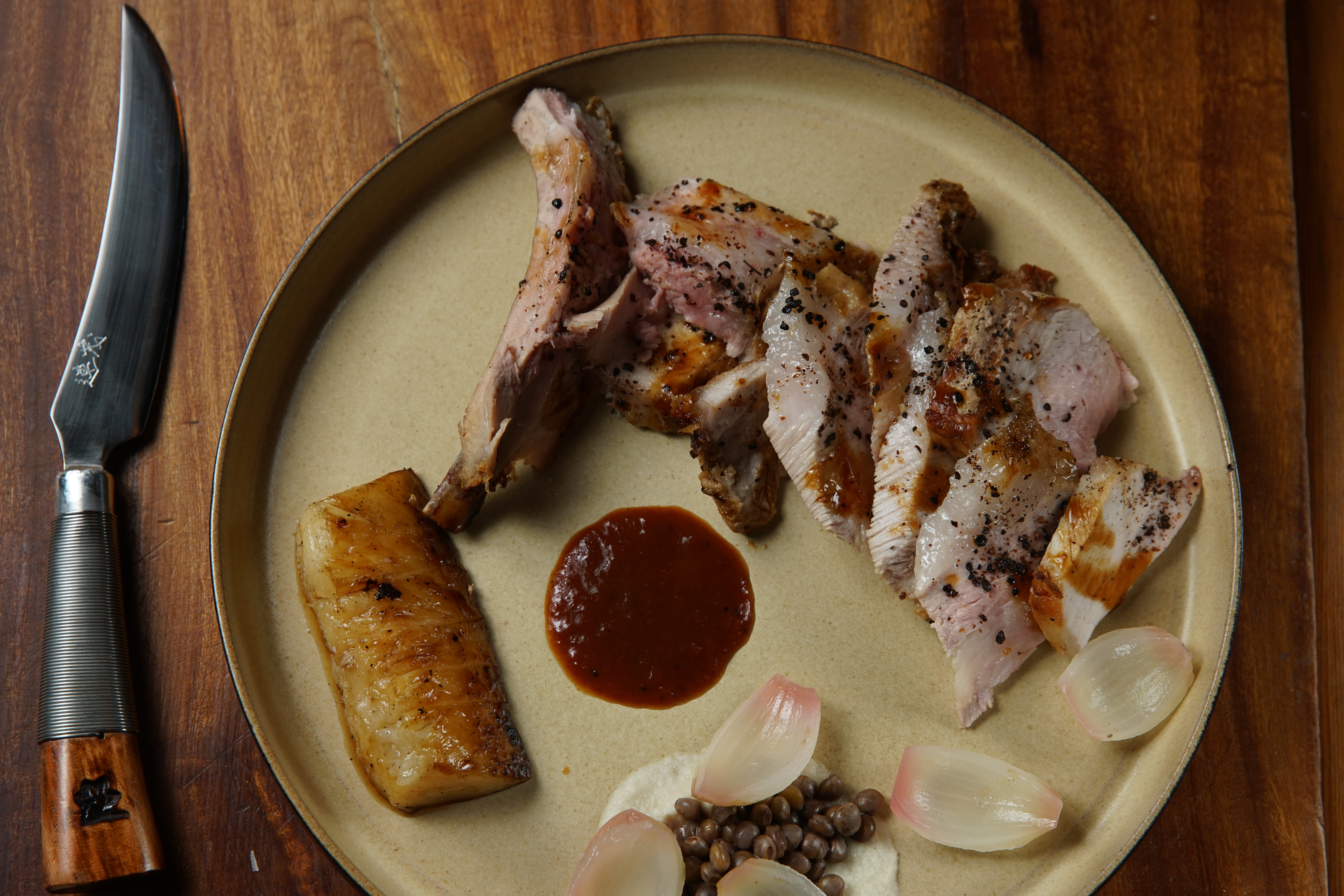 「慢烤帶骨黑豚」搭配的是原住民常食用的樹豆，餐具是縮小版的獵刀。