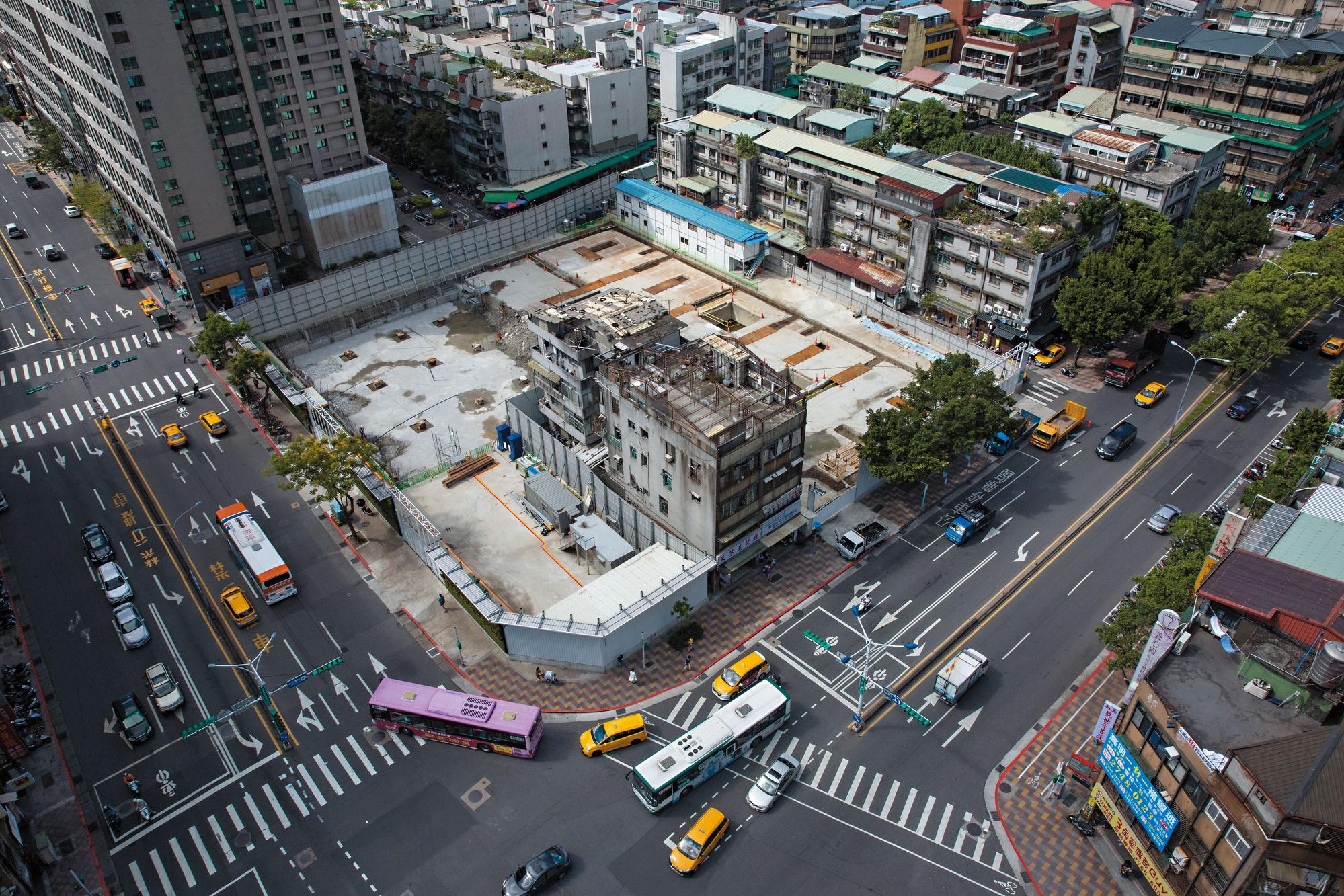 永春都更案位在忠孝東路五段（左側馬路）與松山路（右側馬路）交叉口，左方高樓即位於永春捷運站正上方、每坪百萬元的共構宅E.A.T。