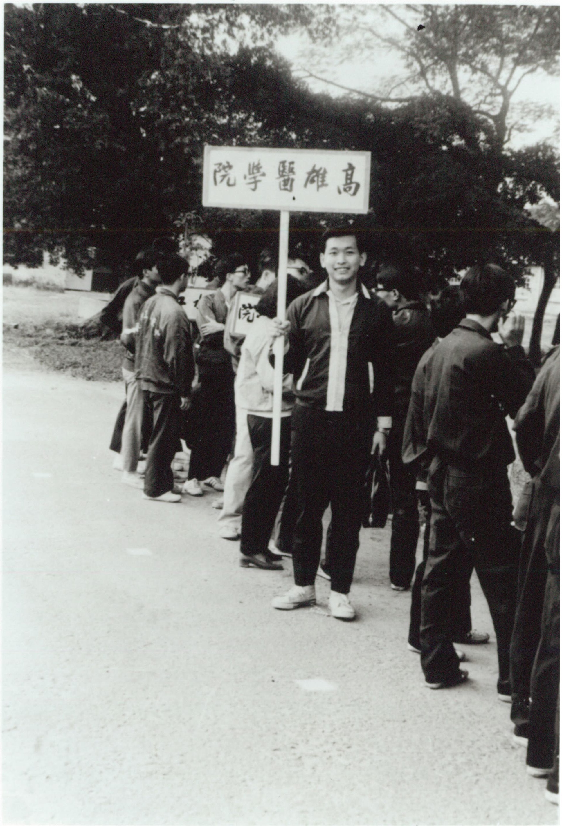 因熱愛桌球，李成家（持牌者）就讀高雄醫學院藥學系時，成為桌球社社長。（李成家提供）