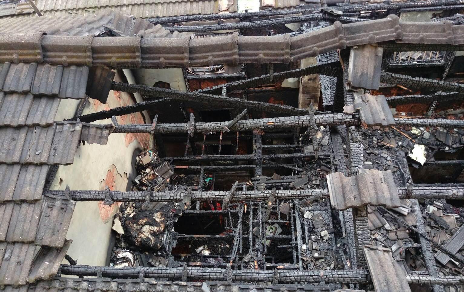整個屋頂燒得塌陷，陳姓男子屍體被屋瓦掩蓋著，成為焦屍。（消防局提供）