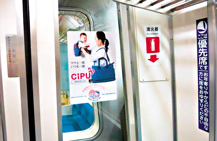 去年11月，東京地鐵大江戶線車廂宣傳「孕婦優先席」的海報上，母子背著喜舖包，目前在新加坡、馬來西亞、香港等地，都有喜舖的實體門市。（周品妤提供）