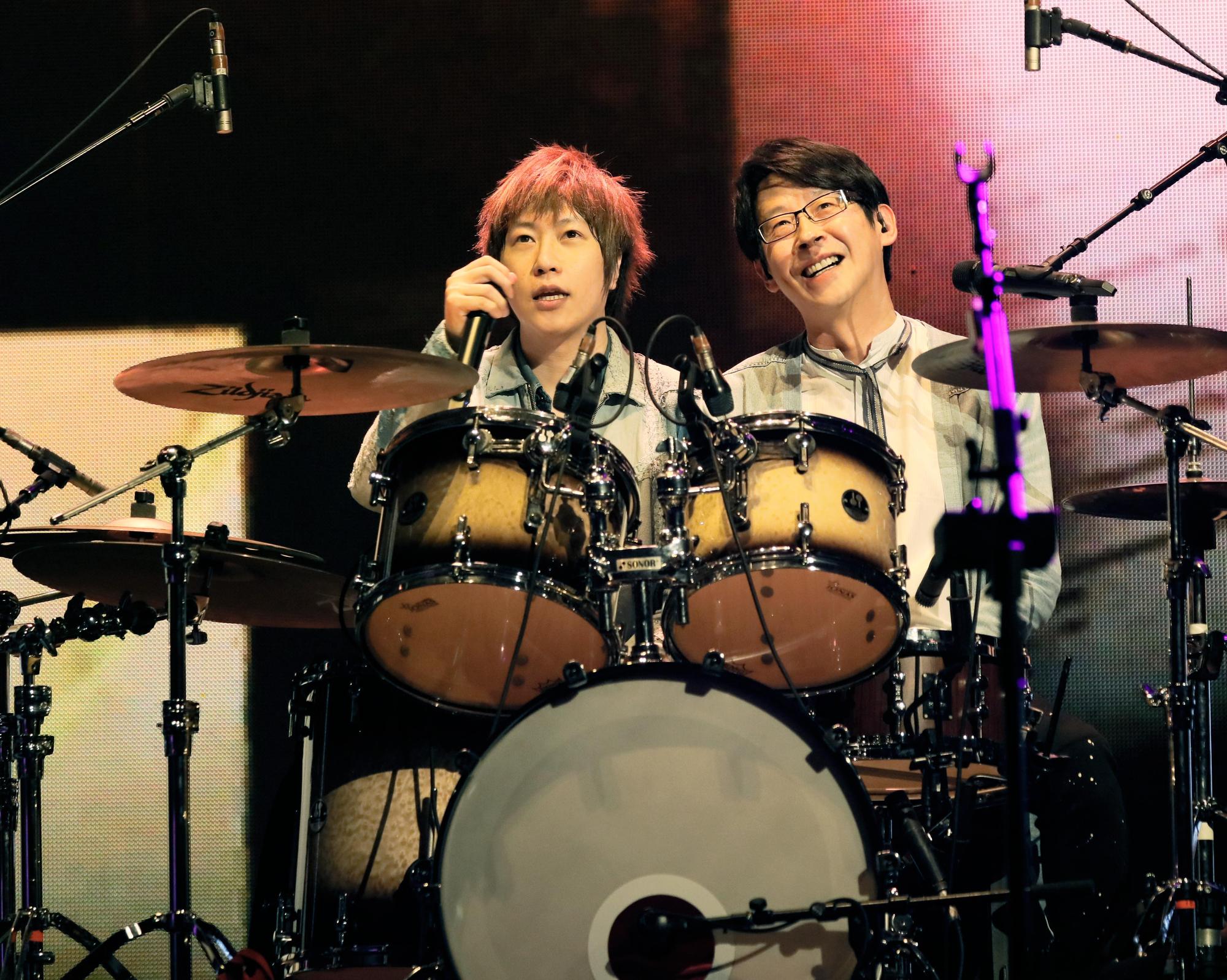 阿信演唱〈我不願讓你一個人〉時要求譜曲的冠佑邊打鼓邊唱,2人默契十足。(相信音樂提供)