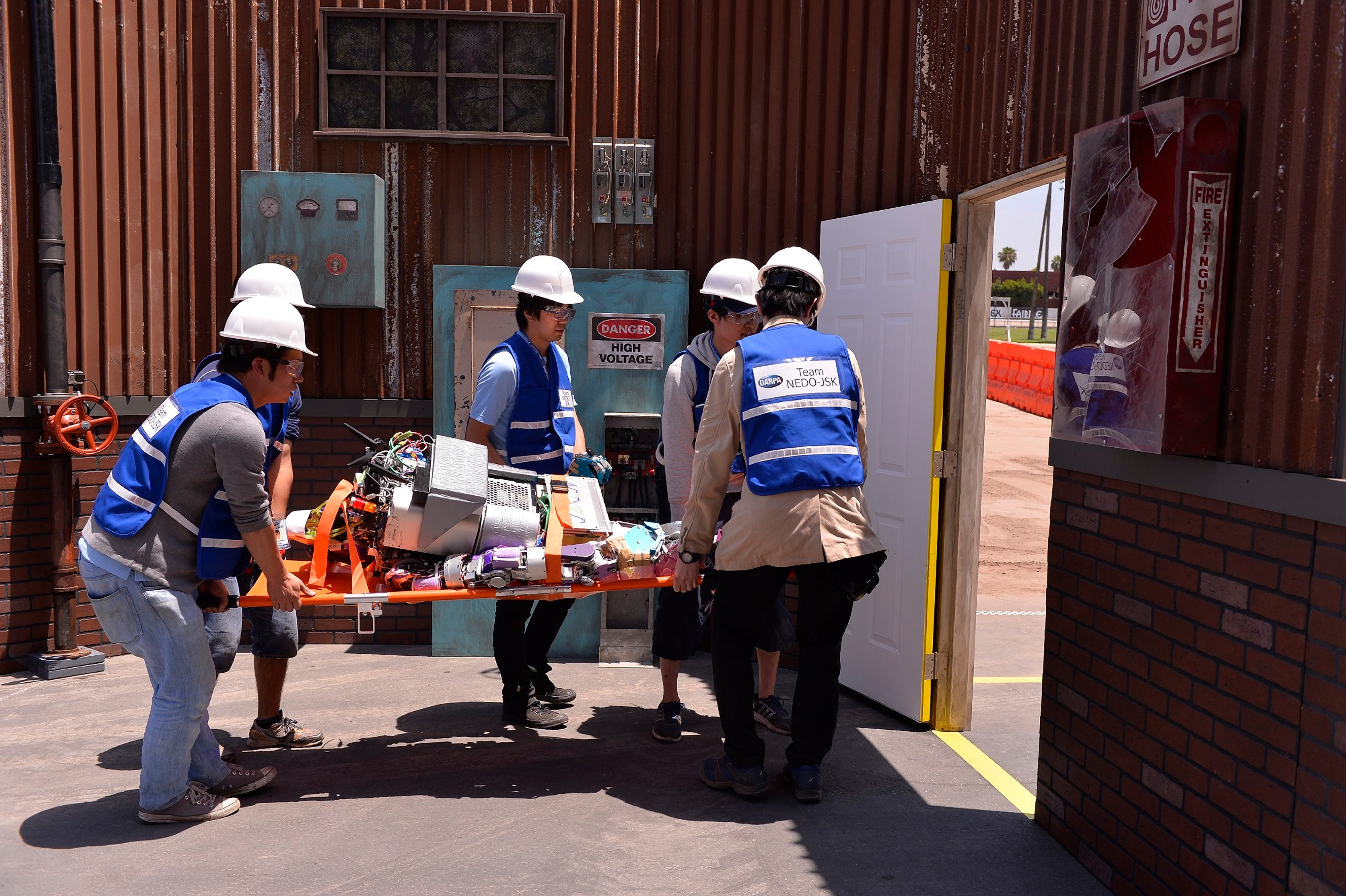 DARPA機器人競賽中,故障的機器人被抬離比賽場地。(東方IC)