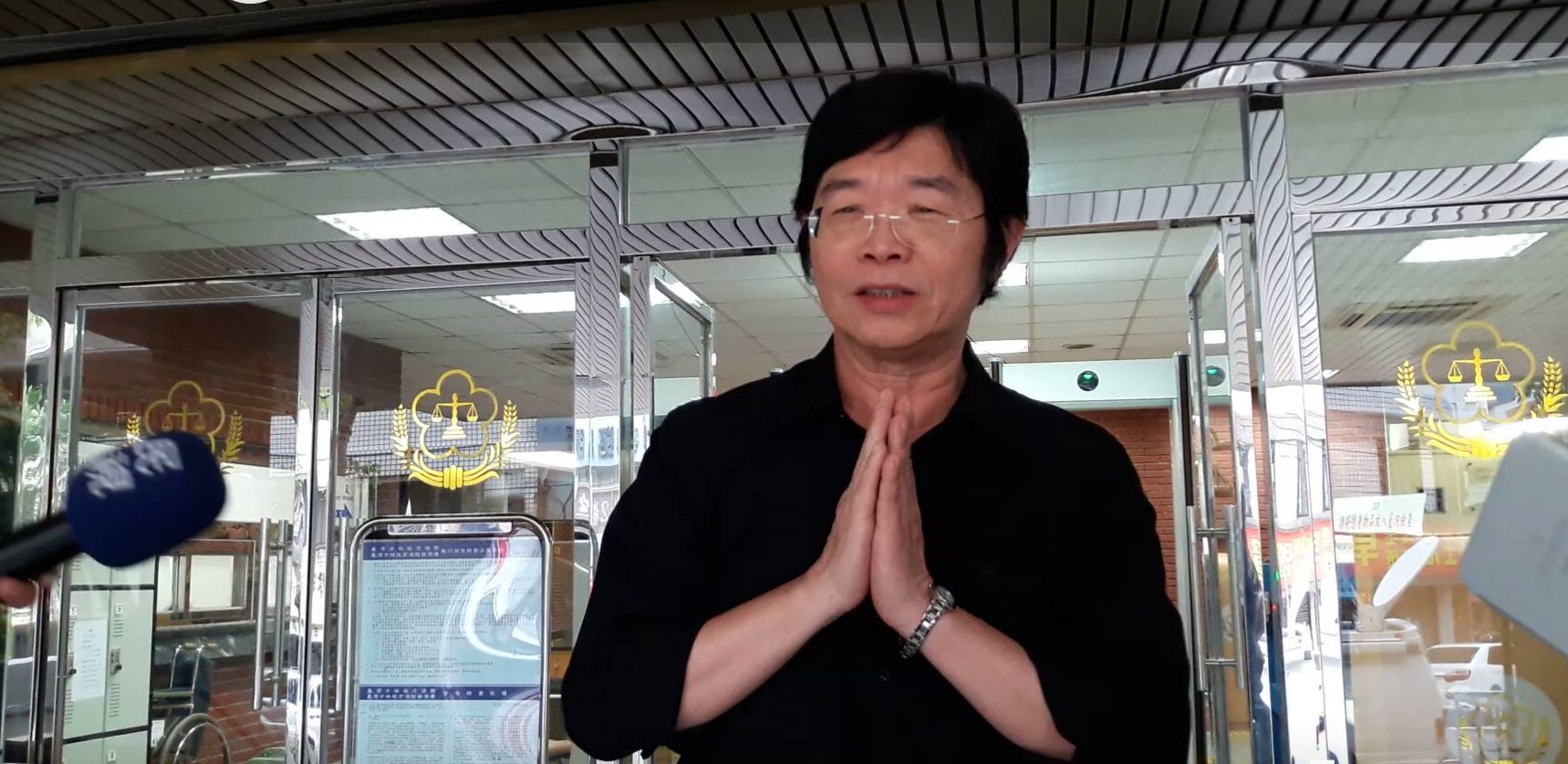 莊圓大師17日開庭後雙手合十，步出法庭，法庭外還有信徒緊跟發傳單。