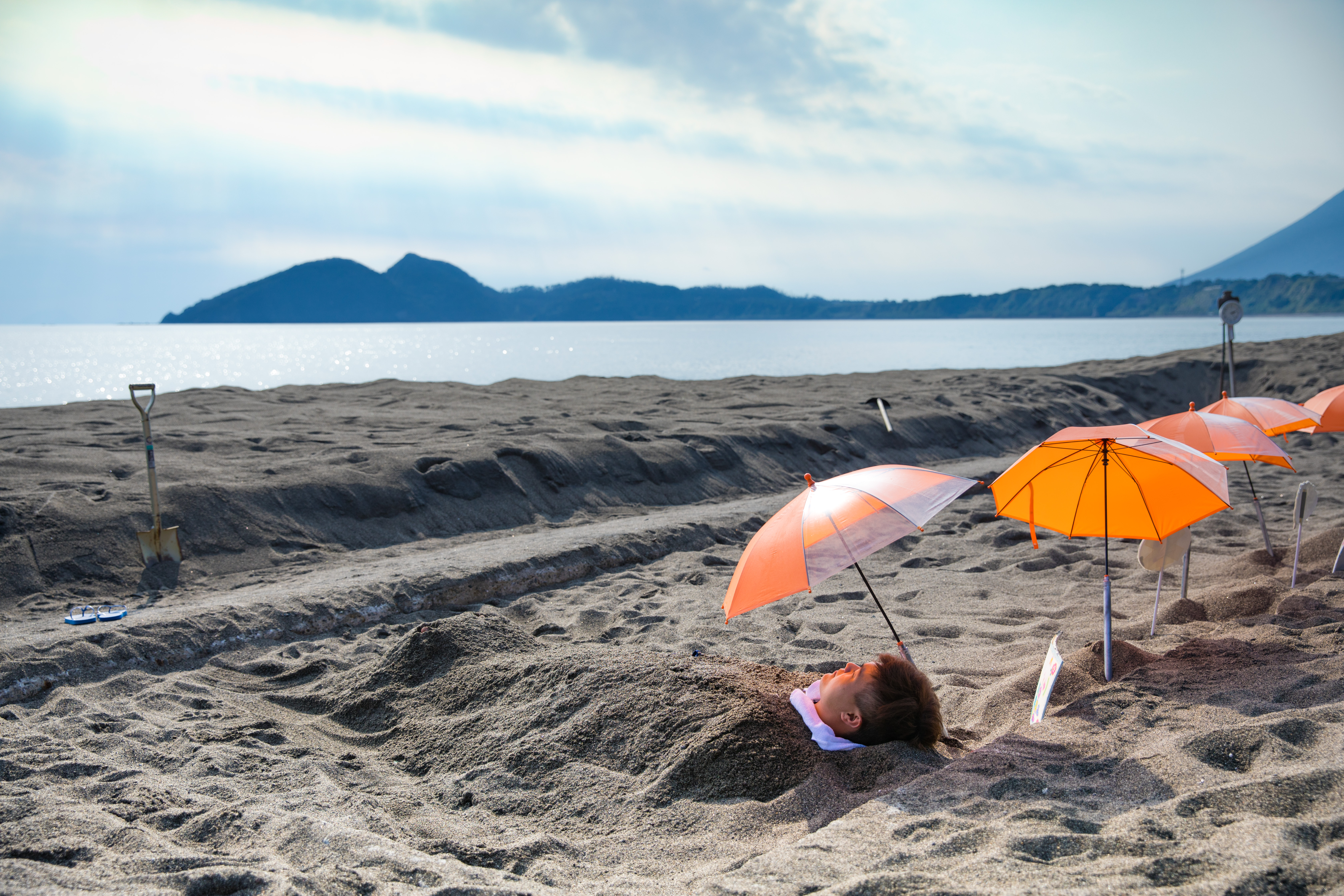 乍看靜謐的海岸景象，實則是被熱砂活埋的苦行地獄。