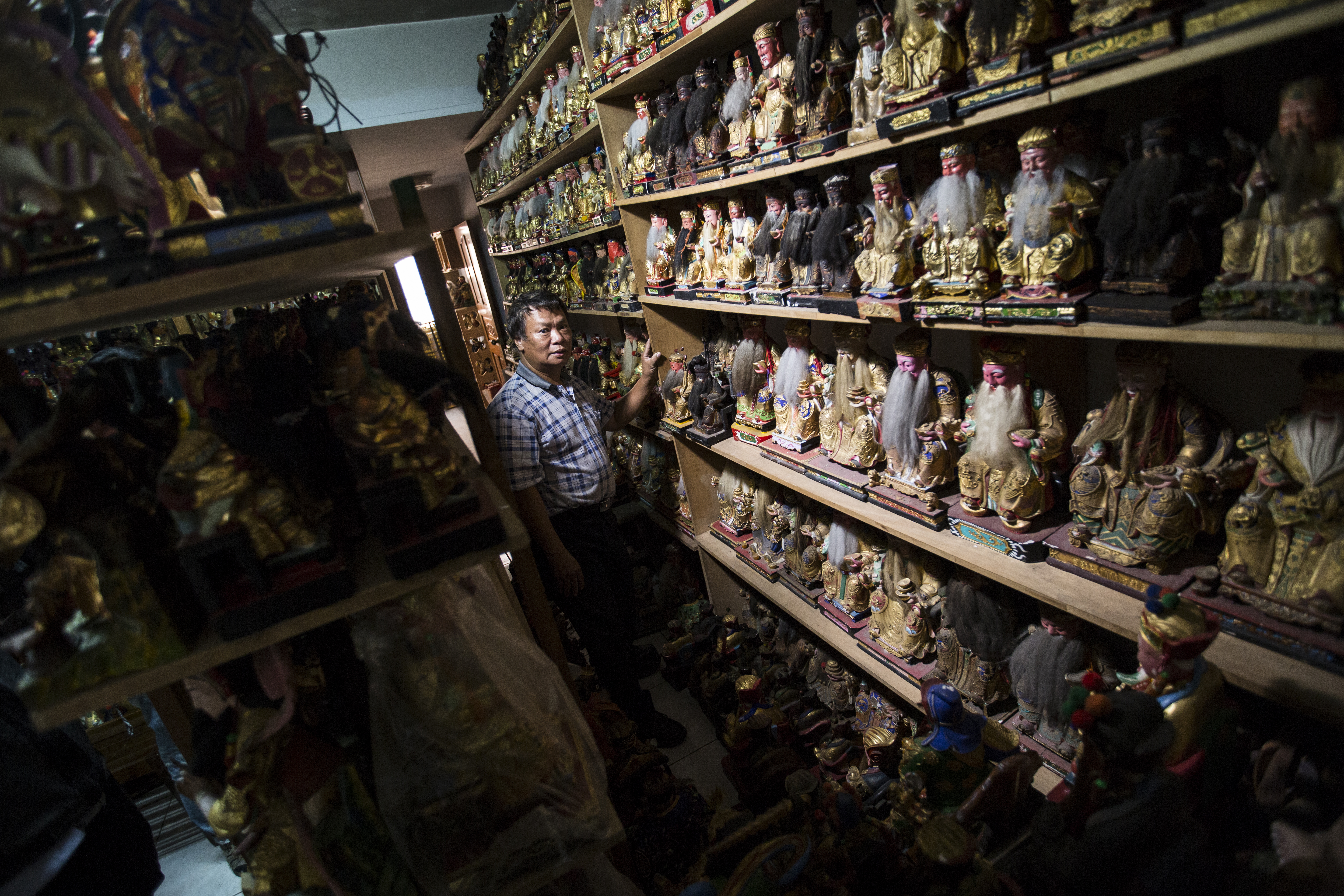 林新來收容神明，木架子一層一層疊至天花板，整間透天厝顯得擁擠，但也讓人感受到林新來的善心。