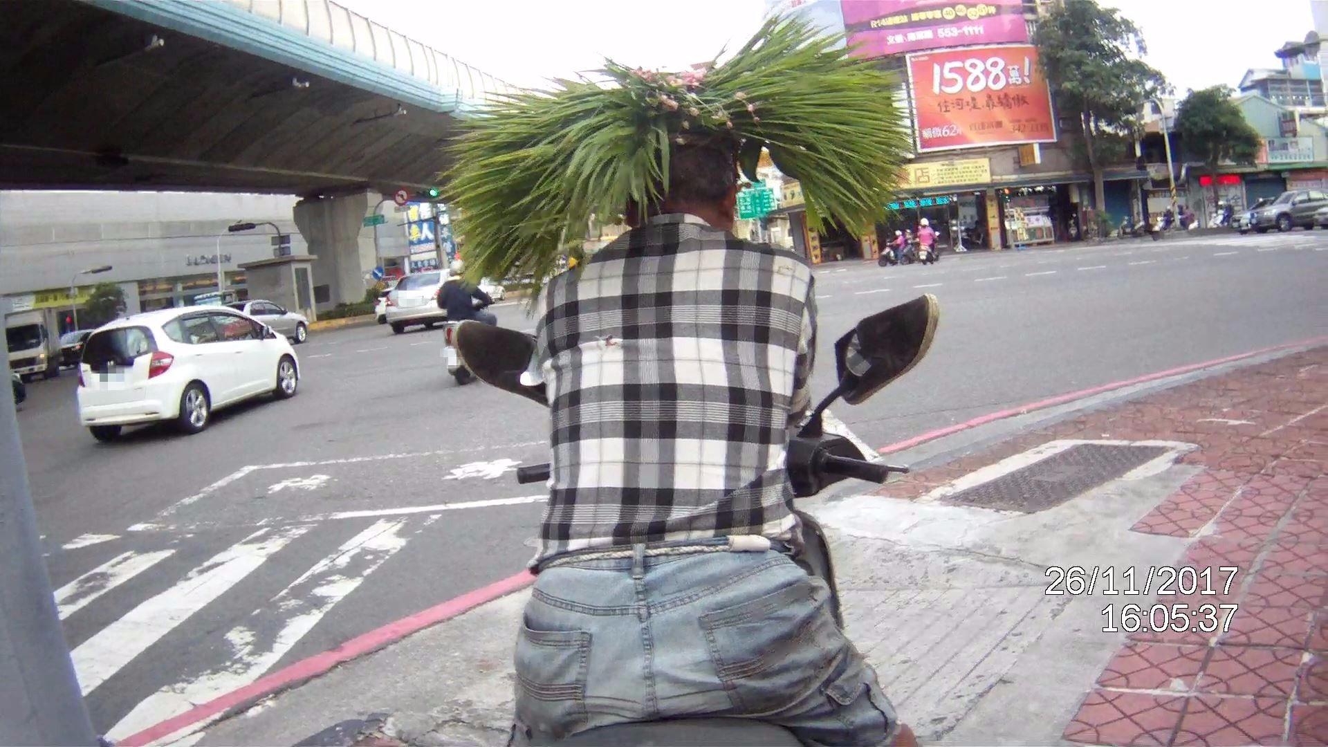 帶著自製草帽馬路騎車反而太醒目， 遭警攔開單。（警方提供）