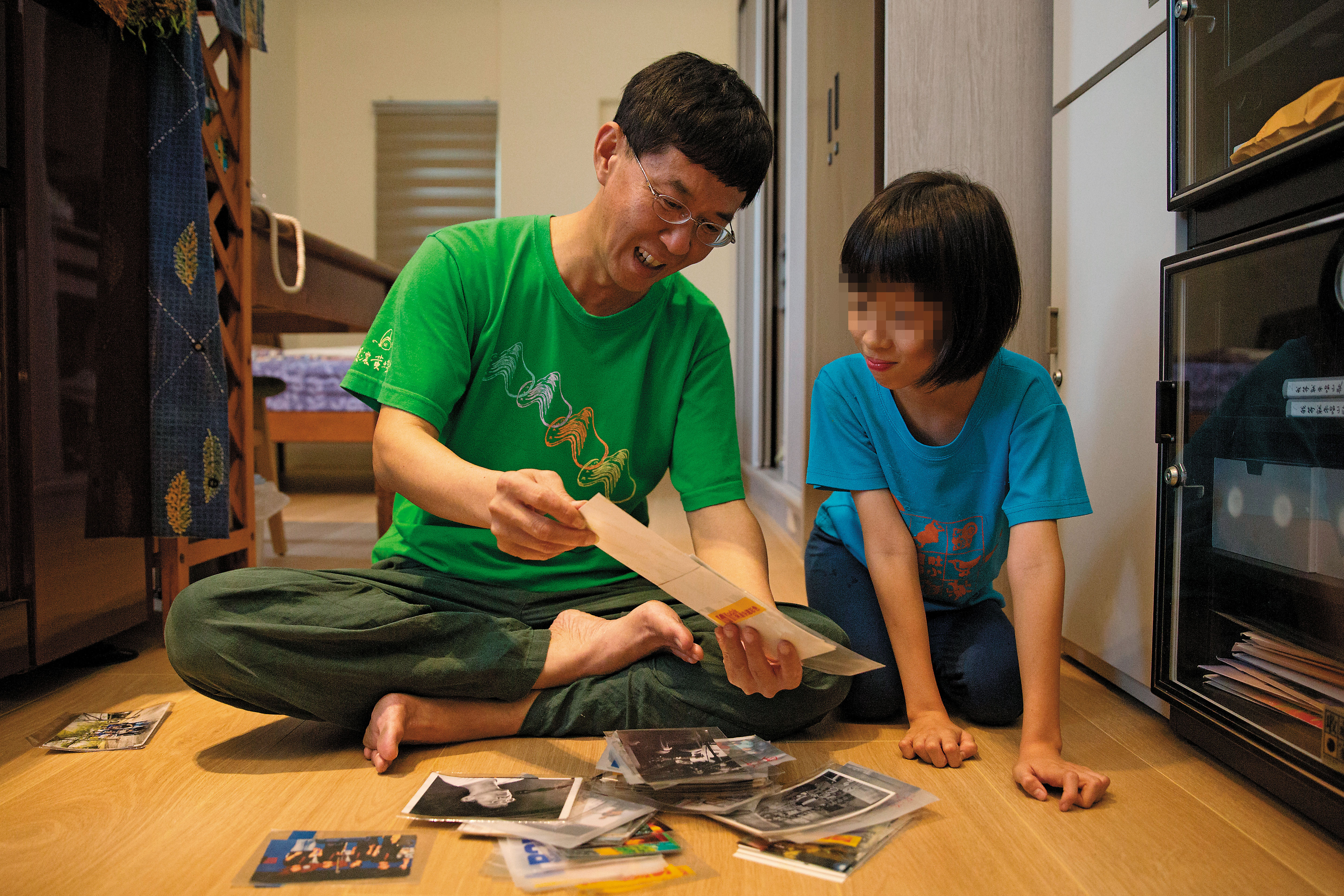 林生祥(左)和女兒阿kiki(右)一起翻看舊照,但他怎麼看都不滿意,最後只願意給我們一張。