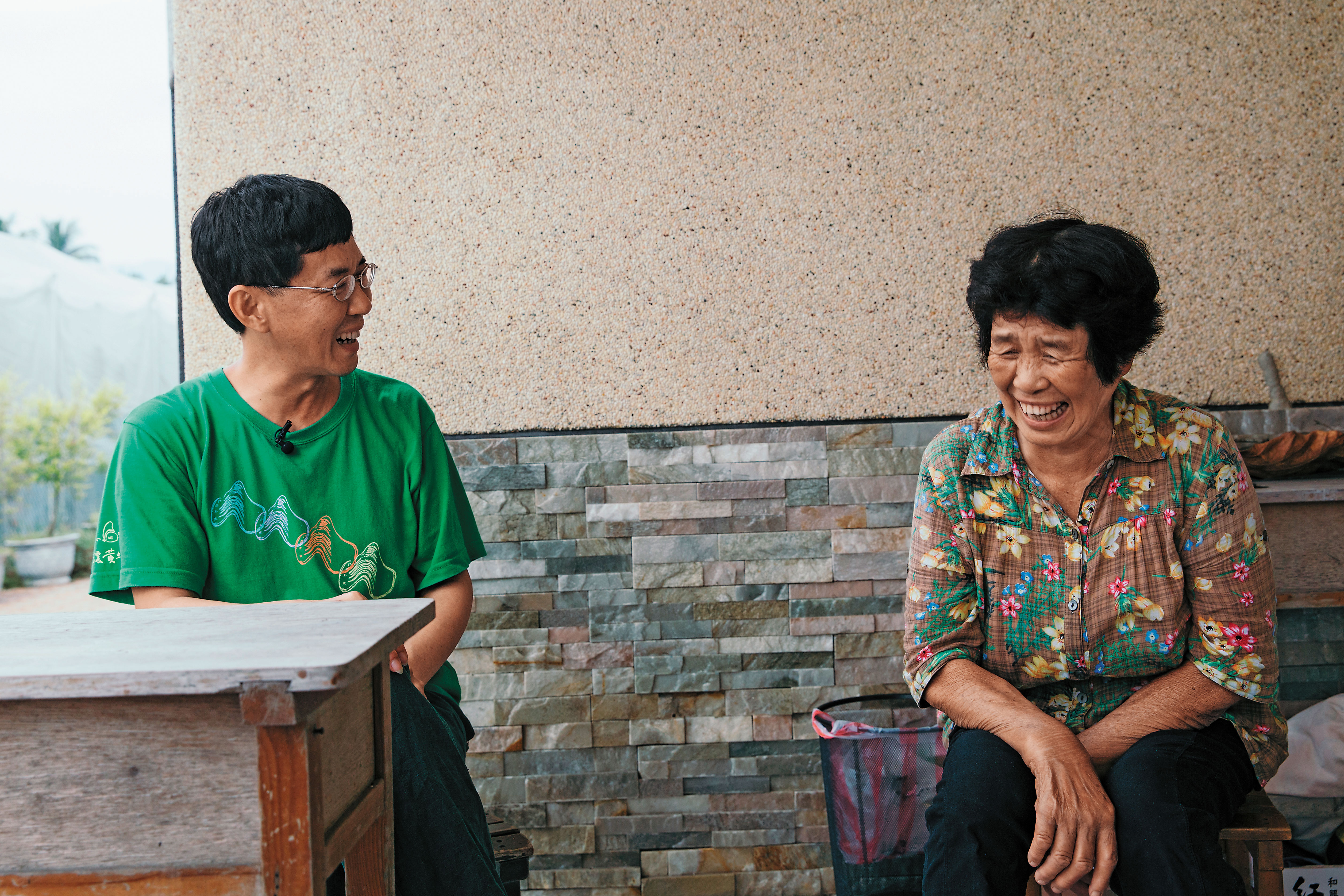 林生祥(左)和母親(右)在住家外和我們閒聊,林媽媽說起往事毫不忸捏,幾度使林生祥不得不出聲阻止或反駁,好像怕爽朗的媽媽一不小心就爆了大料。