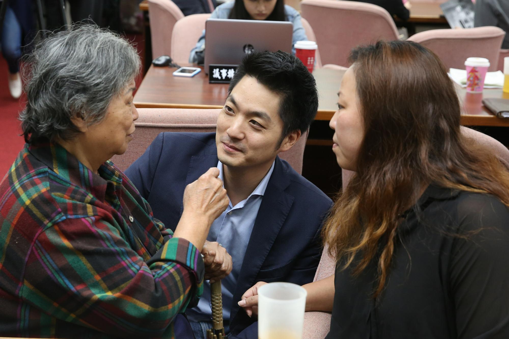 公聽會主席、立委蔣萬安(中)休息時慰問受邀到公聽會的過勞死勞工家屬。