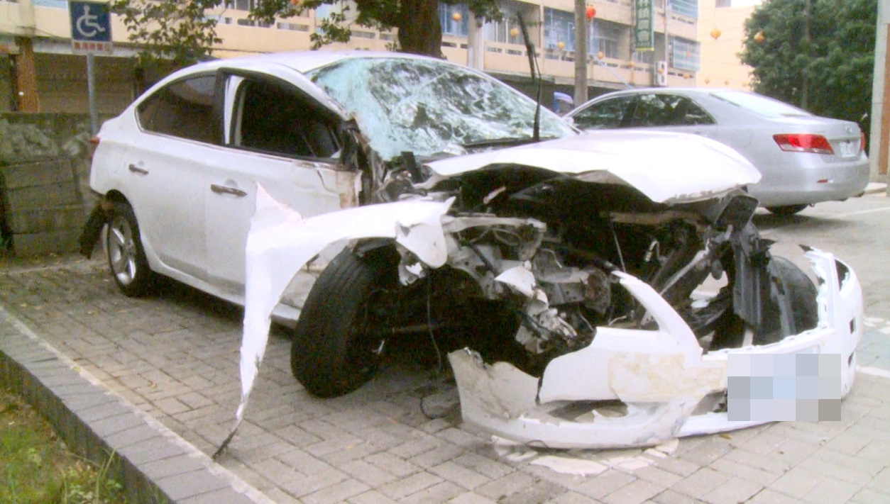 白色轎車車頭全毀，車體扭曲變形，可見當時撞擊力道強烈。（警方提供）