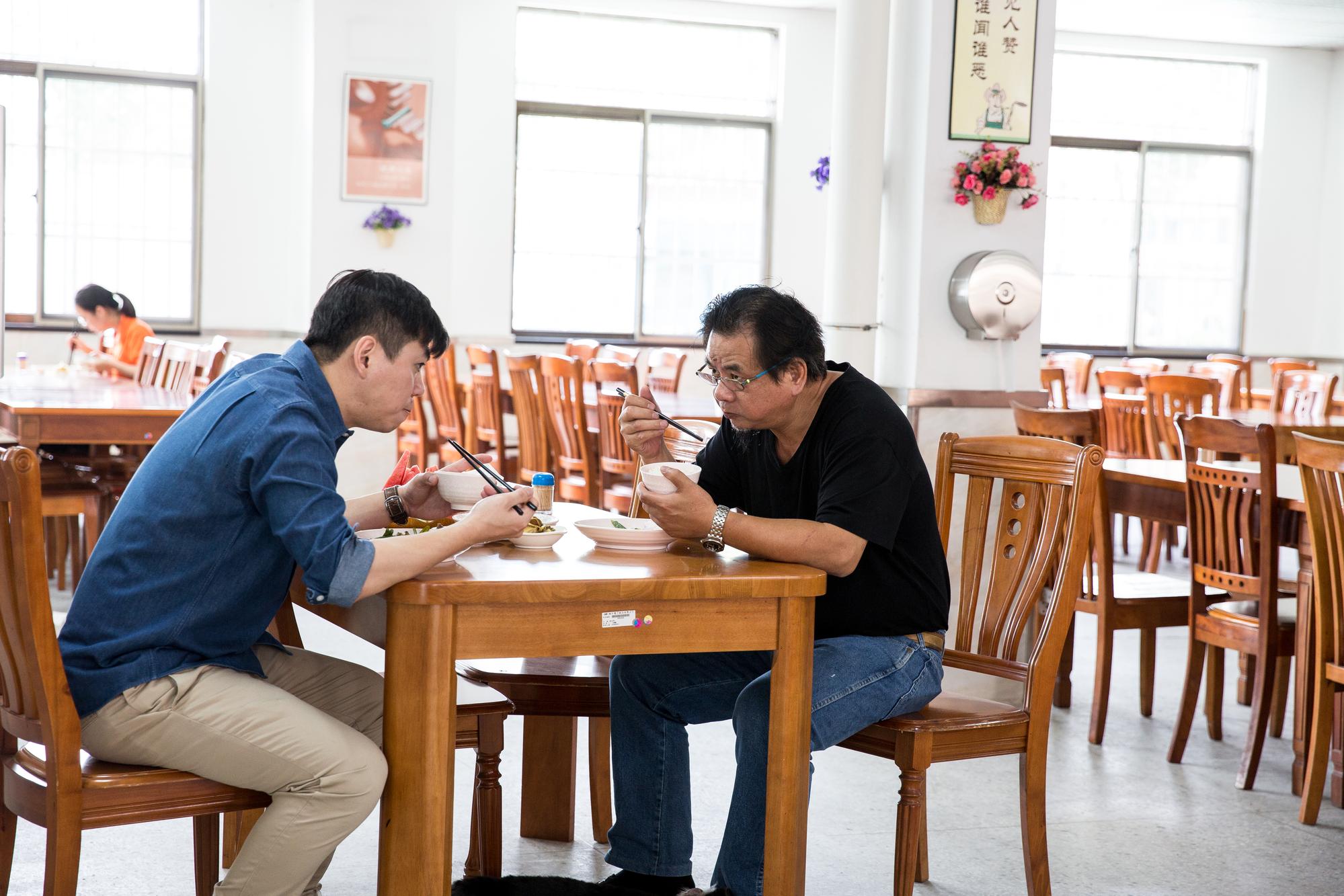 吳瑞雄（右）堅持跟員工吃一樣飯菜，午餐時刻，吳彥霆（左）若有在維熹東莞廠，2人會一起用餐。