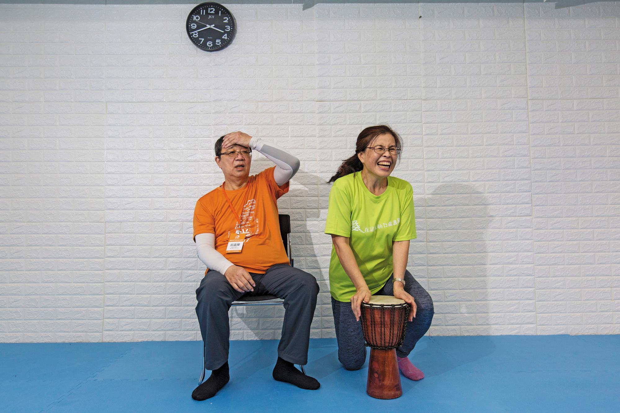 邱孟暉(左)在失智症協會上打鼓課,在妻子莊素玫(右)鼓勵下,2人打鼓合唱台語歌。