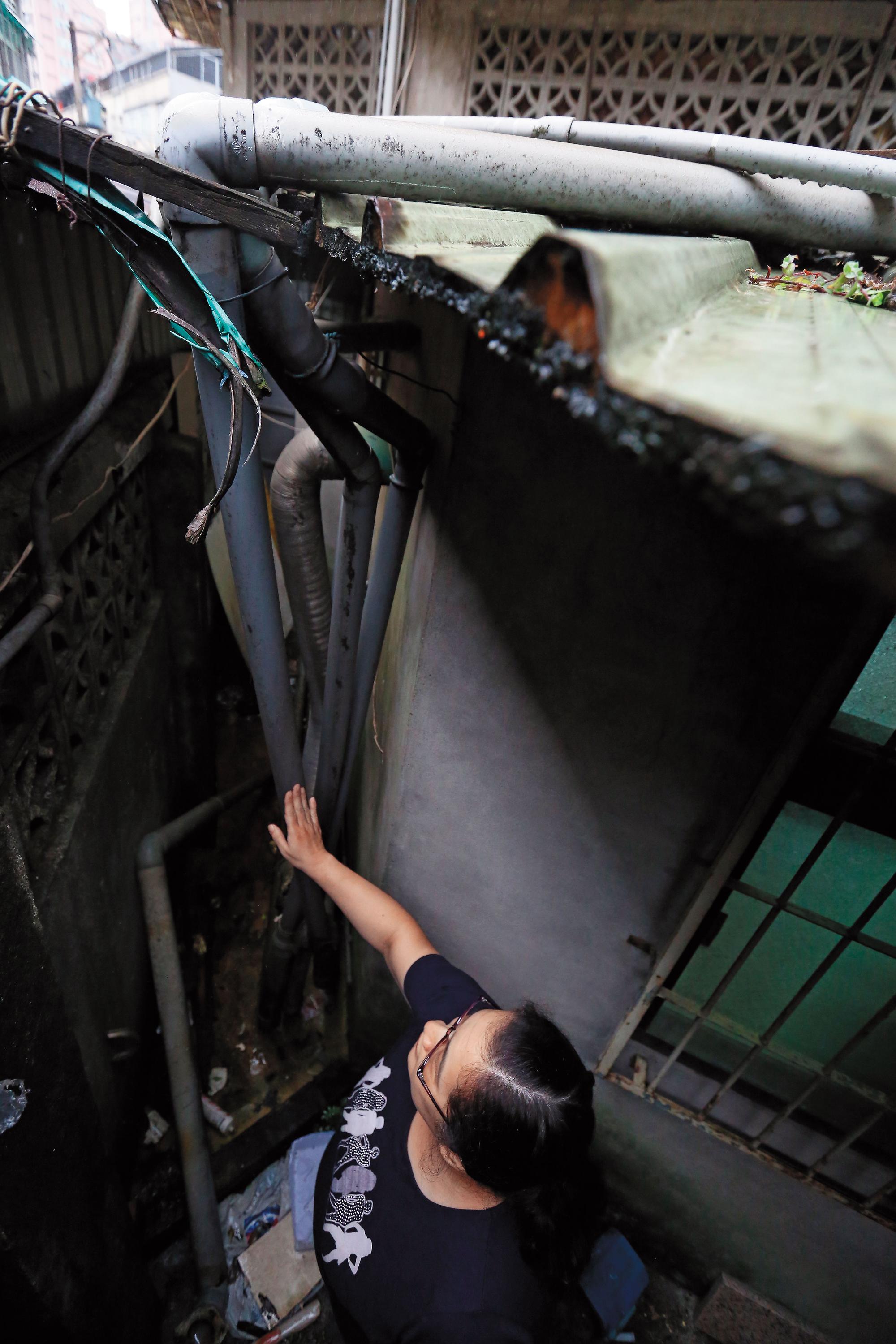 住戶控訴自家後院防火巷被違建戶私接管線占滿，根本失去功能。