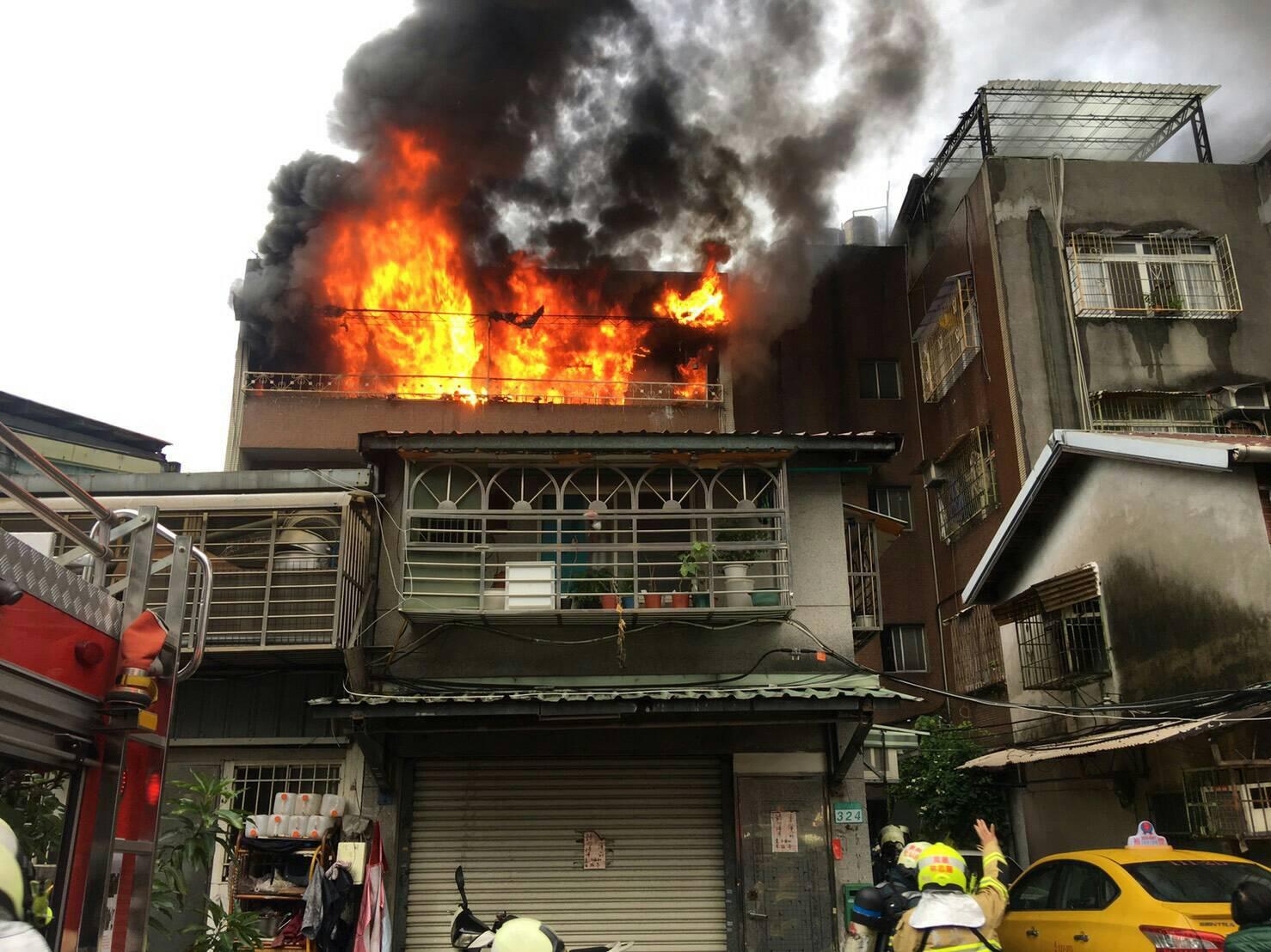 北市萬華區艋岬大道今晨竄火舌，其中一名60歲男子面部被濃煙薰黑嗆傷。（翻攝畫面）