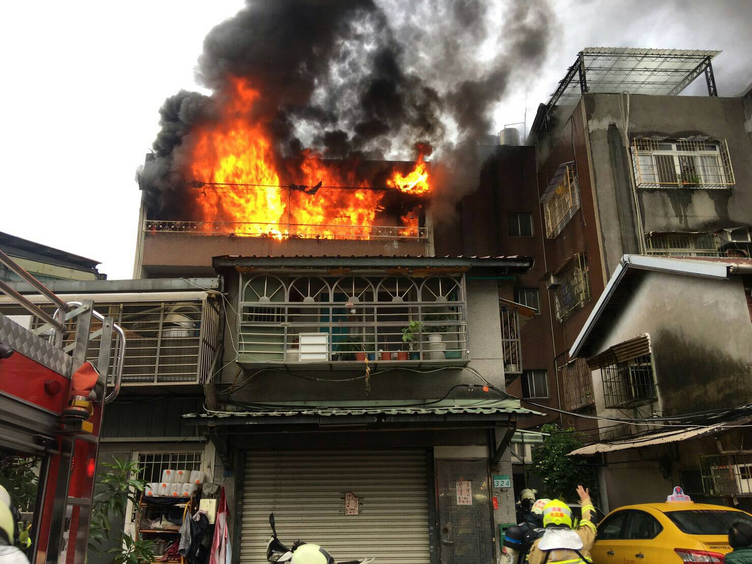 北市萬華區艋岬大道今晨竄火舌，其中一名60歲男子面部被濃煙薰黑嗆傷。（翻攝畫面）