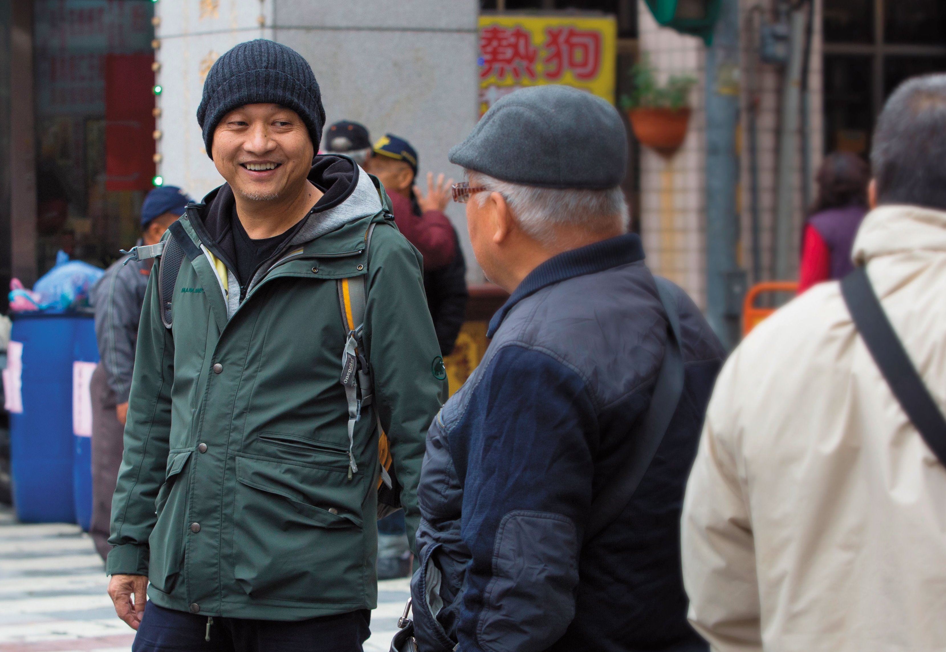 鄭文堂（左）極富親和力，街邊識與不識的攤商、路人，他都能聊上幾句。