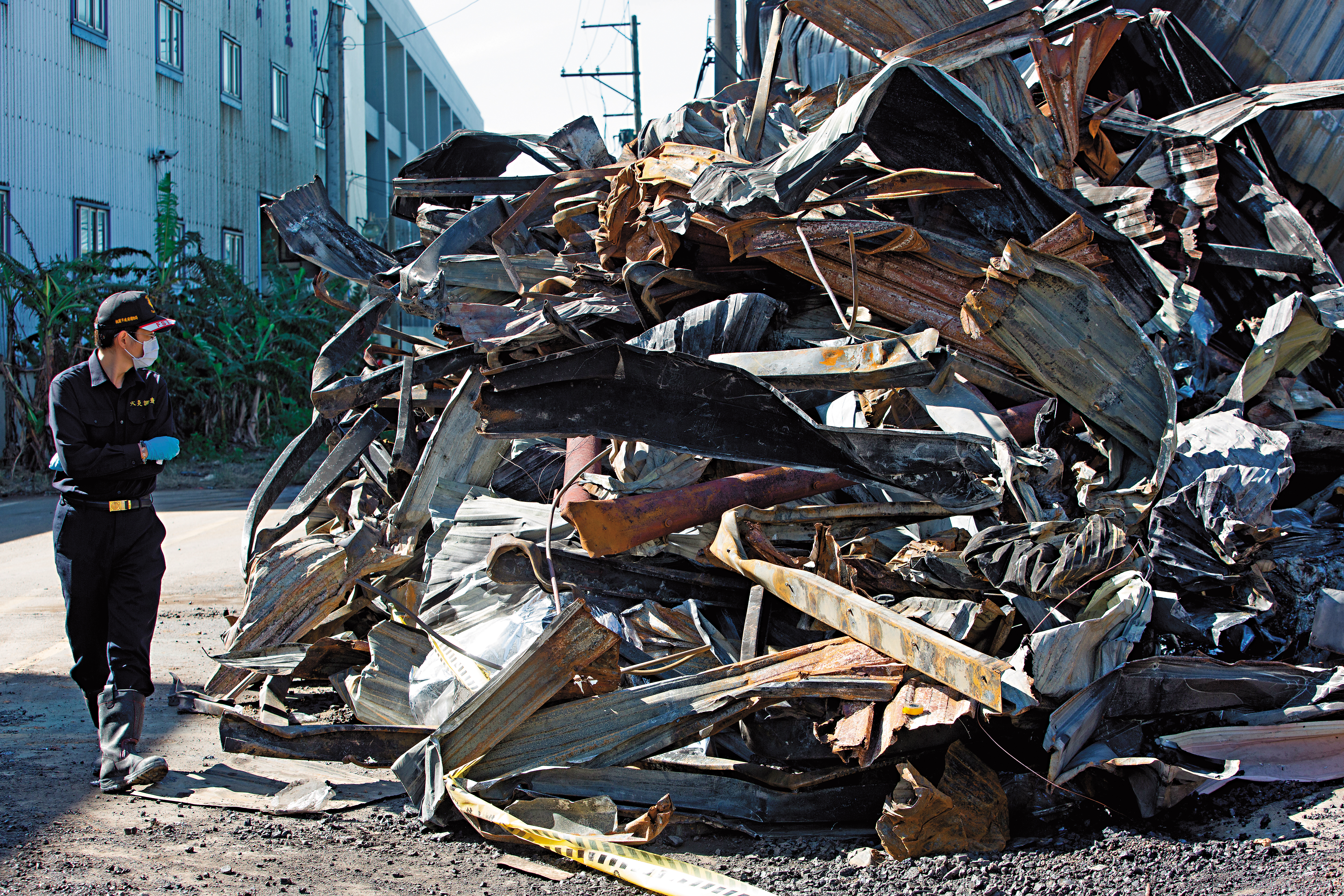20坪鐵皮倉庫付之一炬，消防鑑識人員在現場勘驗起火點。