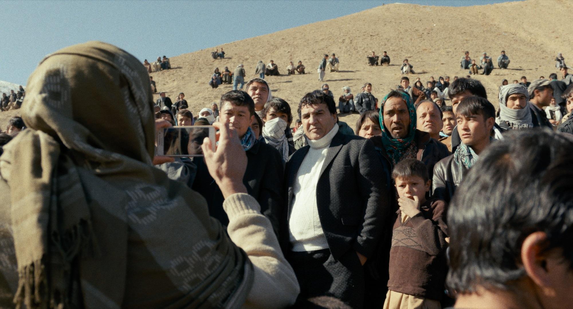 阿富汗電影奇人沙林珊辛（中）在當地很受民眾愛戴，所到之處都有人搶著與他合照。（安可電影提供）